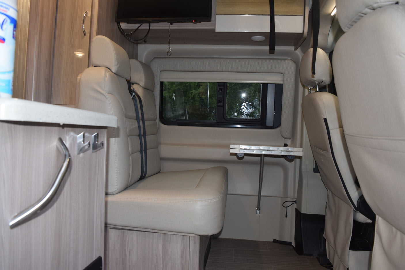 Step inside this RV rental, featuring comfortable seating, a fold-down table, and entertainment for your next road trip adventure.
