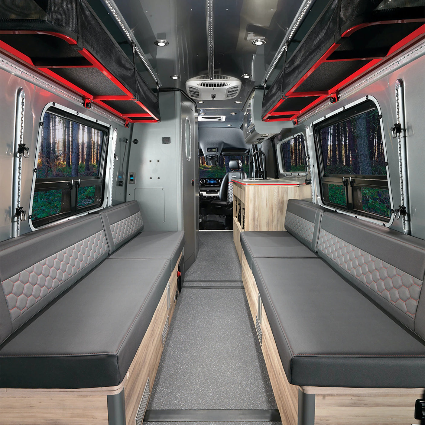 Explore this RV rental's spacious interior with comfy bench seats, overhead storage, and kitchen, offering great forest views.