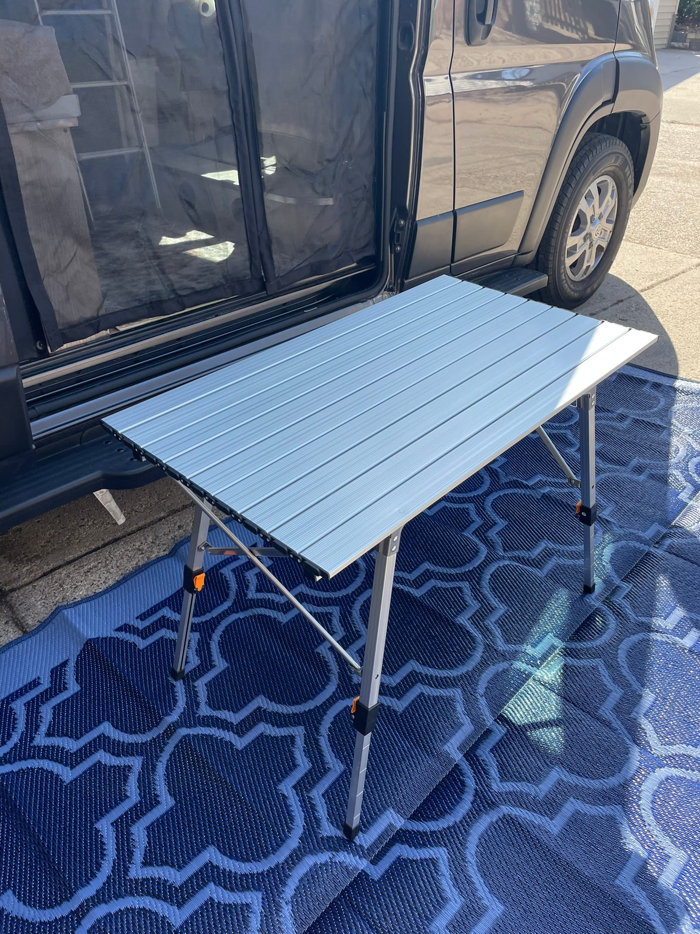 and a ladder to an overhead sleeping bunk.|Cozy RV rental interior featuring a patterned rug