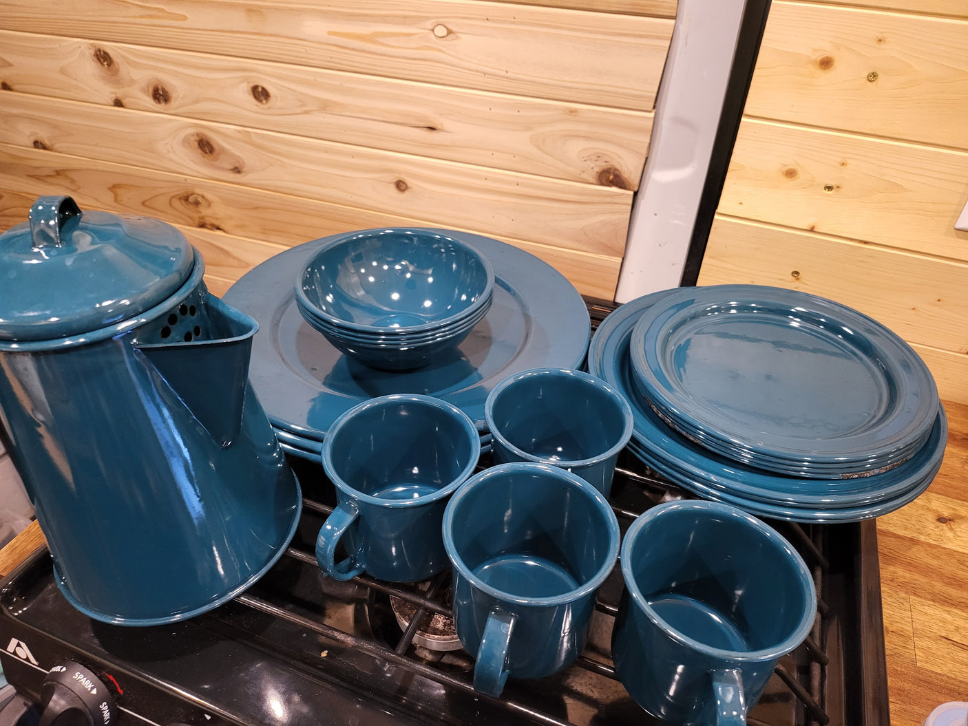 Blue enamelware camping dishes & coffee pot on an RV rental stove. Ideal for your next outdoor adventure.