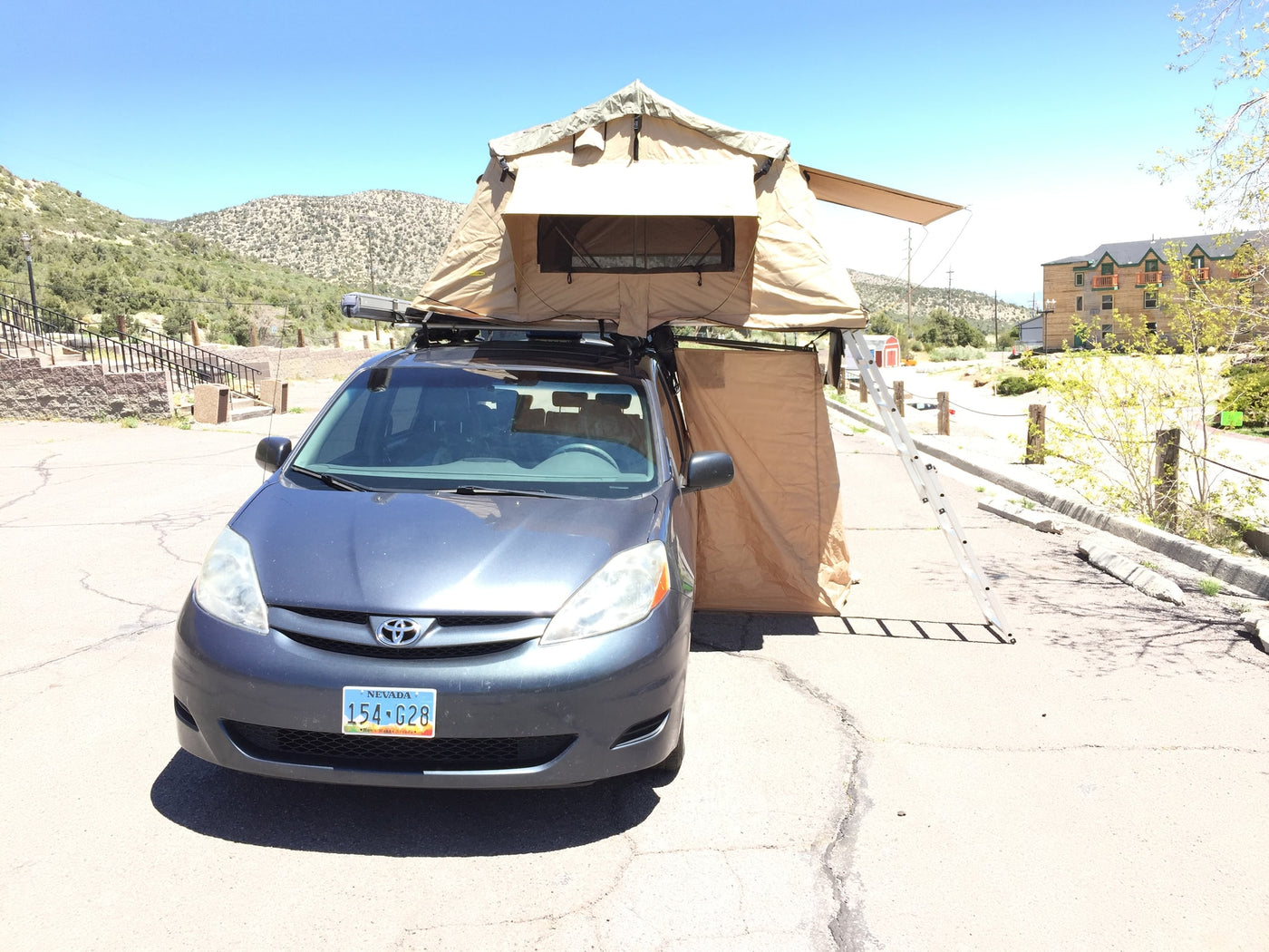 parked outdoors near a lodge.|Car with attached awning tent & kitchen setup — photo 8