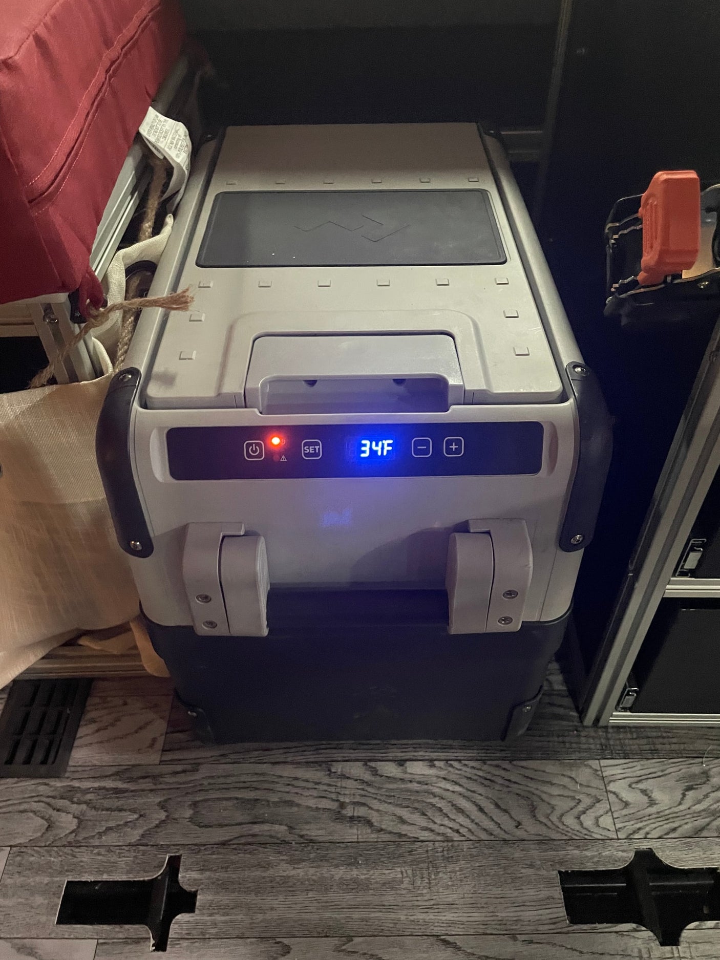 An RV rental's portable cooler displays 34F, ensuring fresh food for travel adventures.