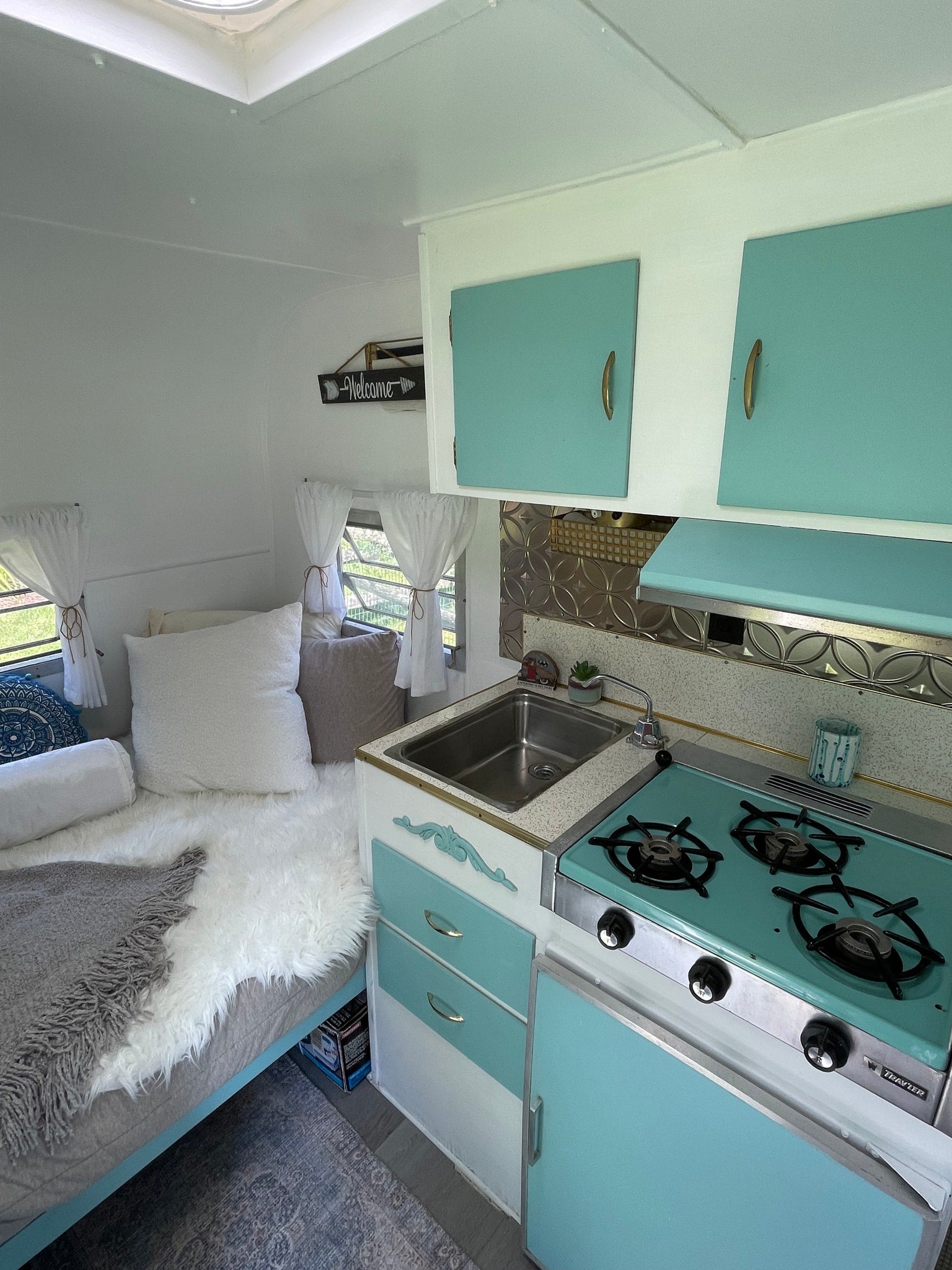 creating a bright and inviting space.|Cozy RV rental interior with retro teal accents