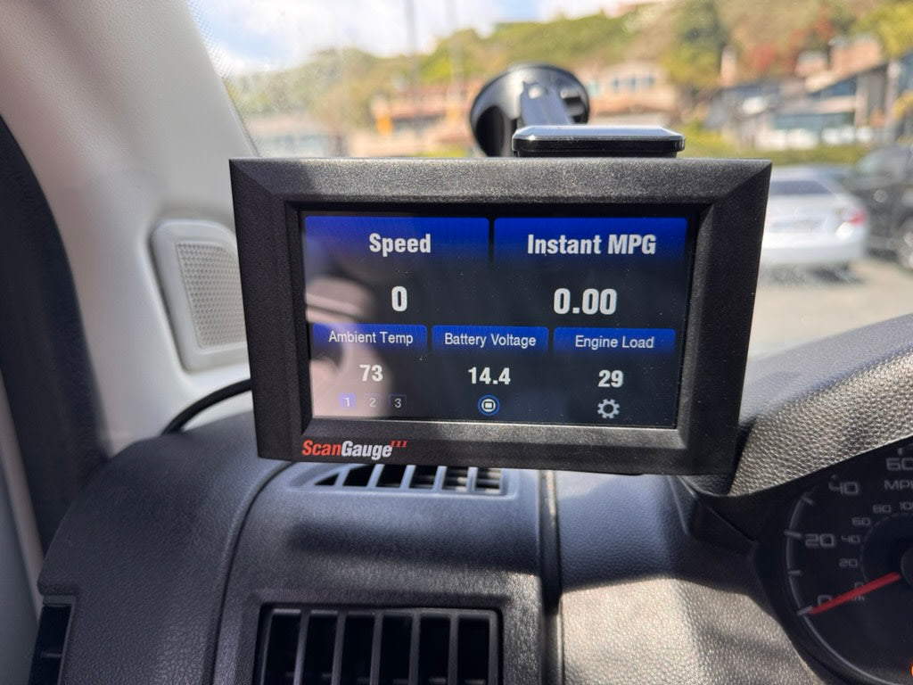 ScanGauge in an rv rental displays vehicle data: speed 0, ambient 73°F, battery 14.4V, and engine load 29.