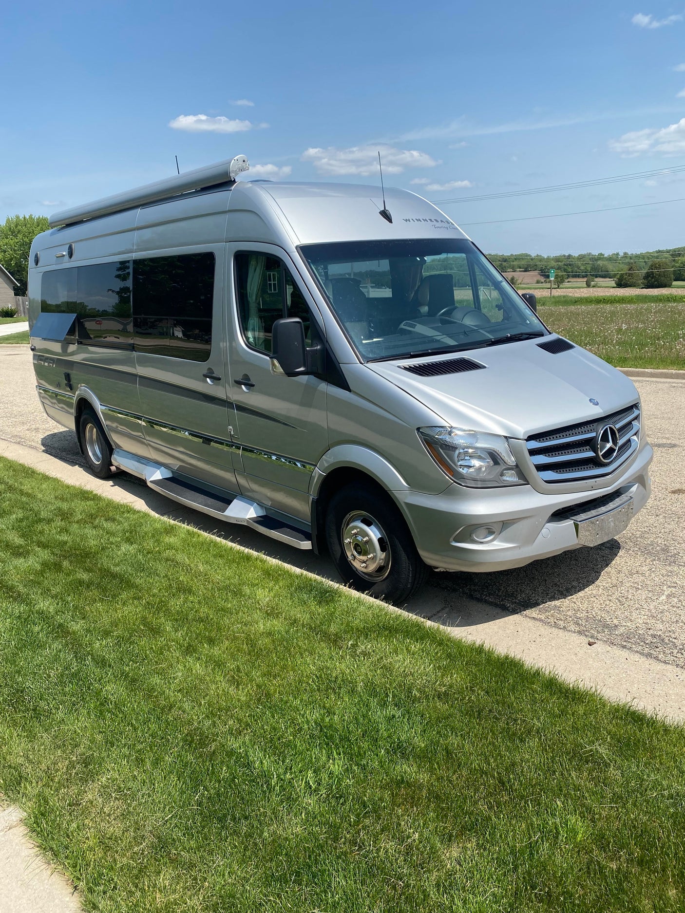 A sleek silver Mercedes Sprinter Winnebago camper van, perfect for your next RV rental journey, parked on a sunny day.