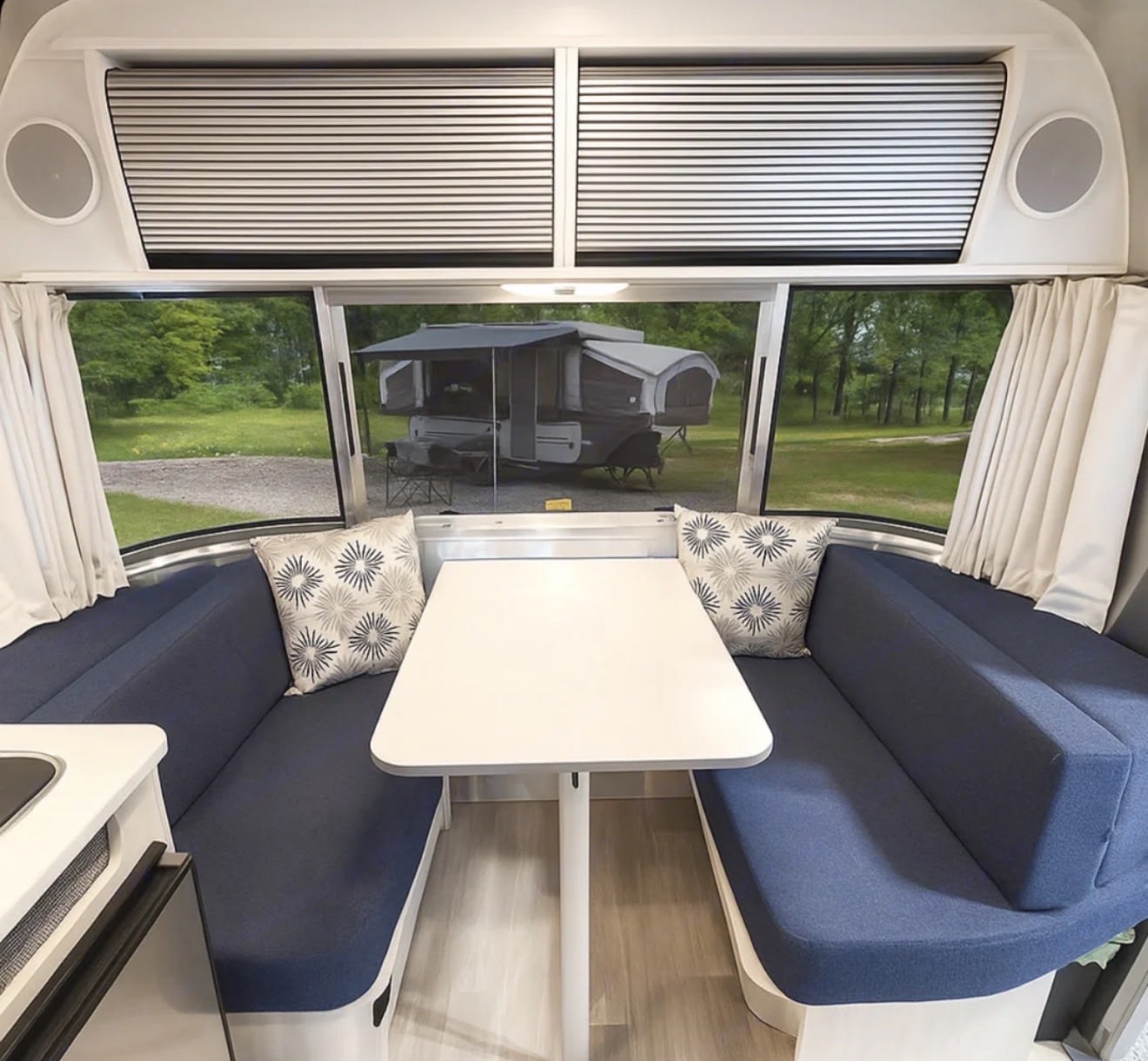 perfect for travel trailer adventures.|Cozy RV rental bedroom featuring a comfortable bed and a window view of another camper outside.|Experience comfort in this RV rental's compact bathroom. Includes a toilet
