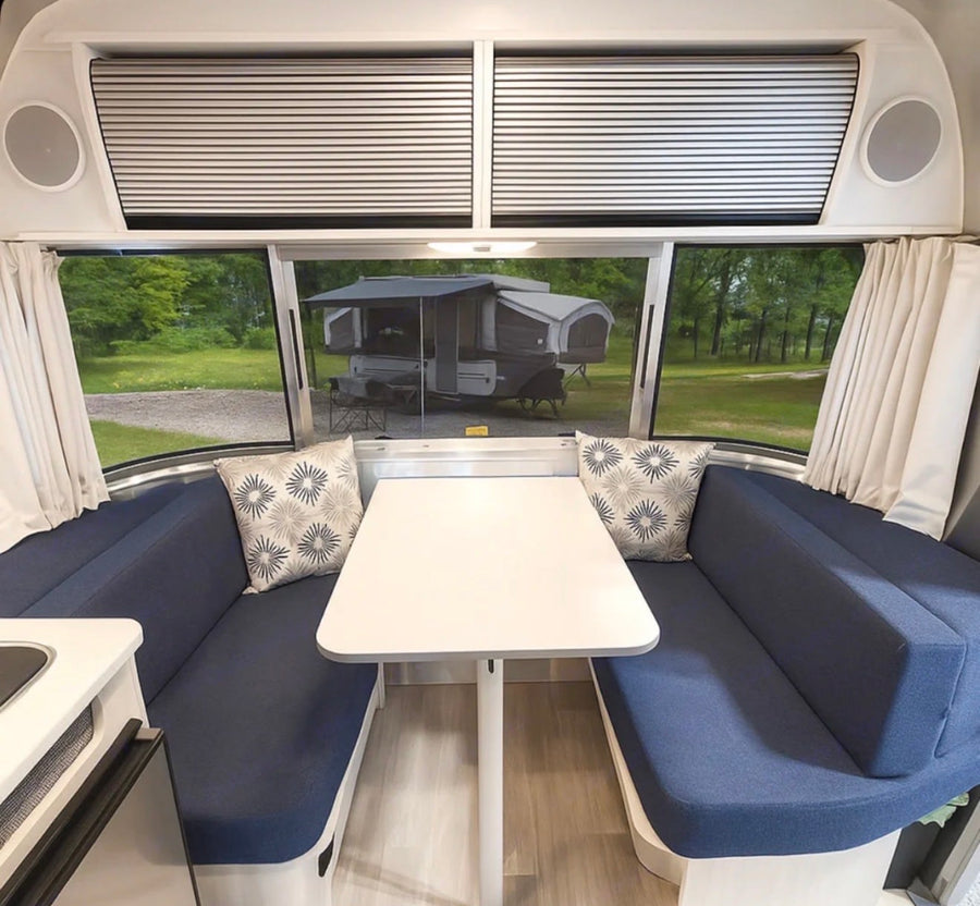 perfect for travel trailer adventures.|Cozy RV rental bedroom featuring a comfortable bed and a window view of another camper outside.|Experience comfort in this RV rental's compact bathroom. Includes a toilet