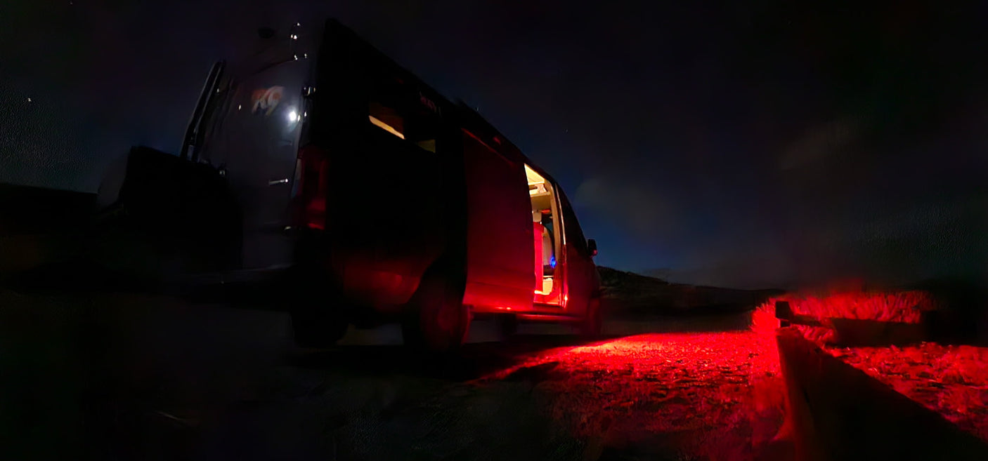 Nighttime adventure with an RV rental. A campervan with an open door and red light on the ground under a dark sky, perfect for camping.