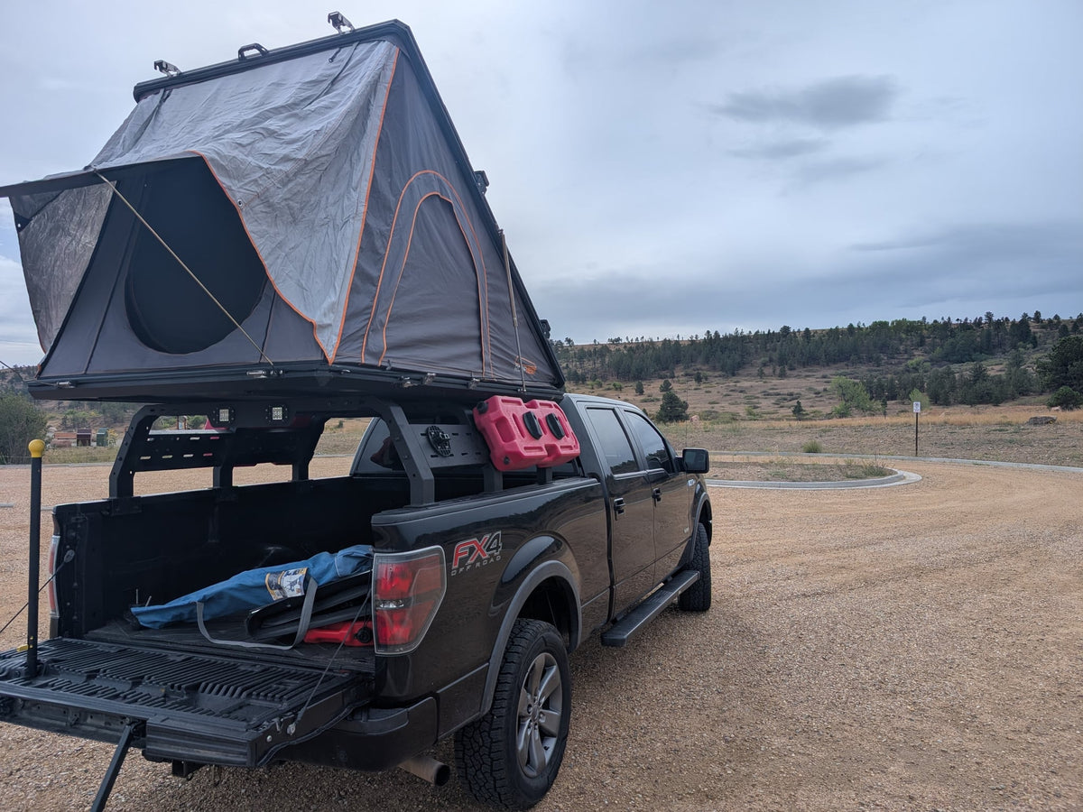 ready for adventure.|A black Ford F-150 with a rooftop tent and gear — photo 2