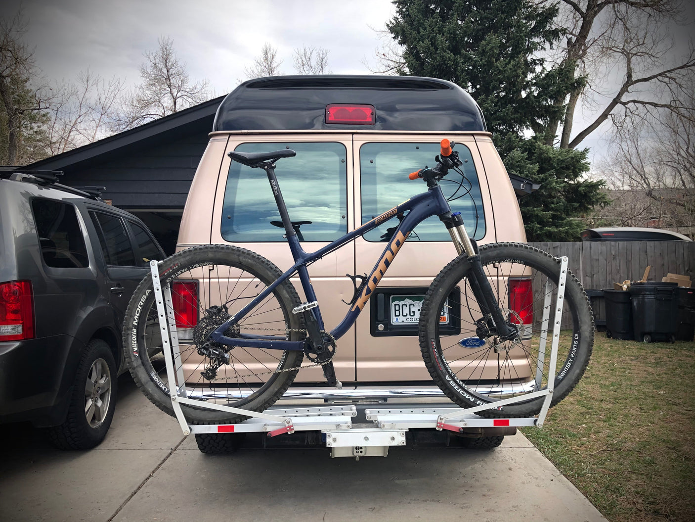 Tan RV rental with a Kona mountain bike on a hitch rack. Ready for off-road adventures!