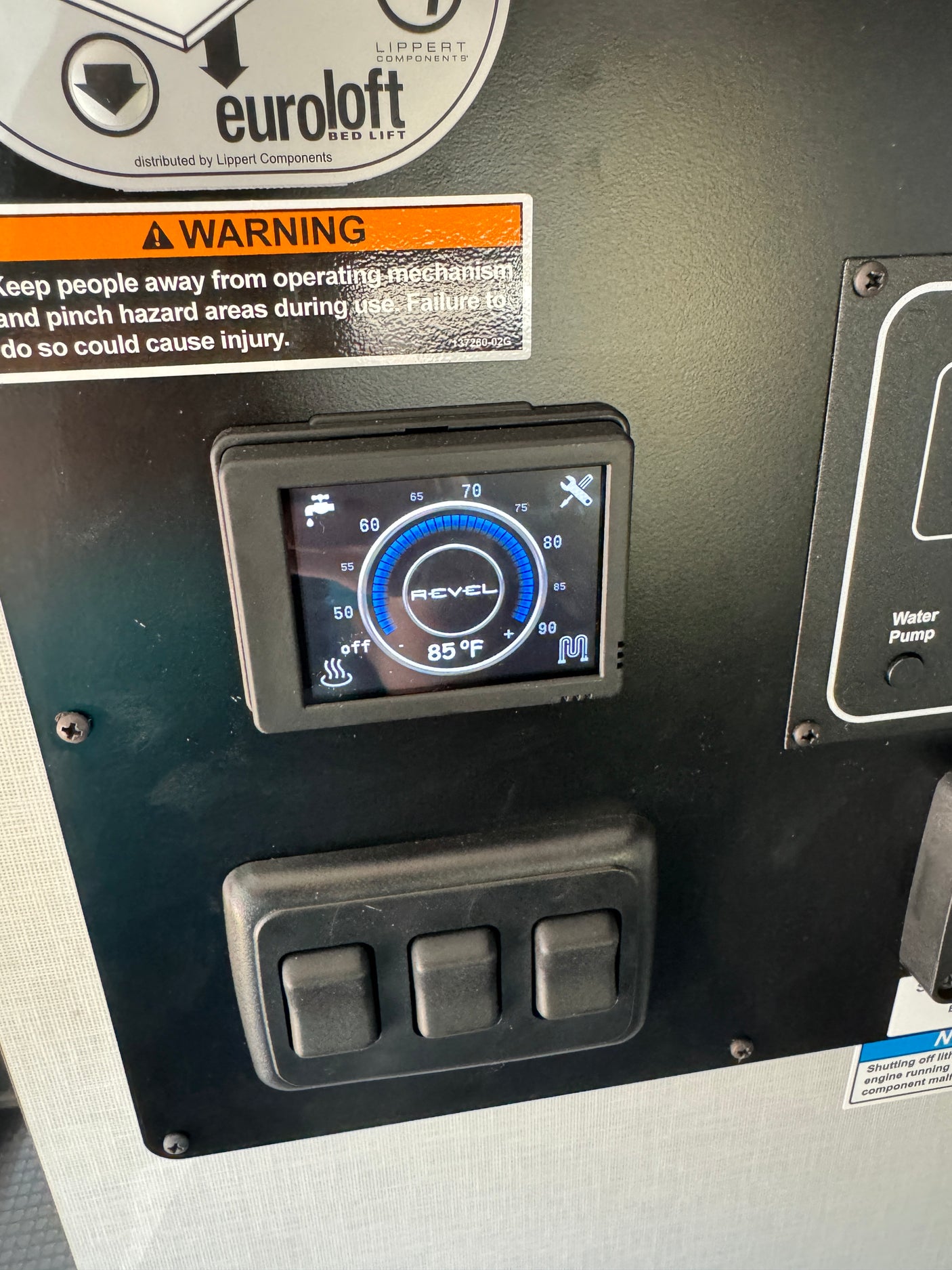 An RV rental control panel: Digital display shows 85°F water temperature, heating status, and warning for bed lift mechanism.