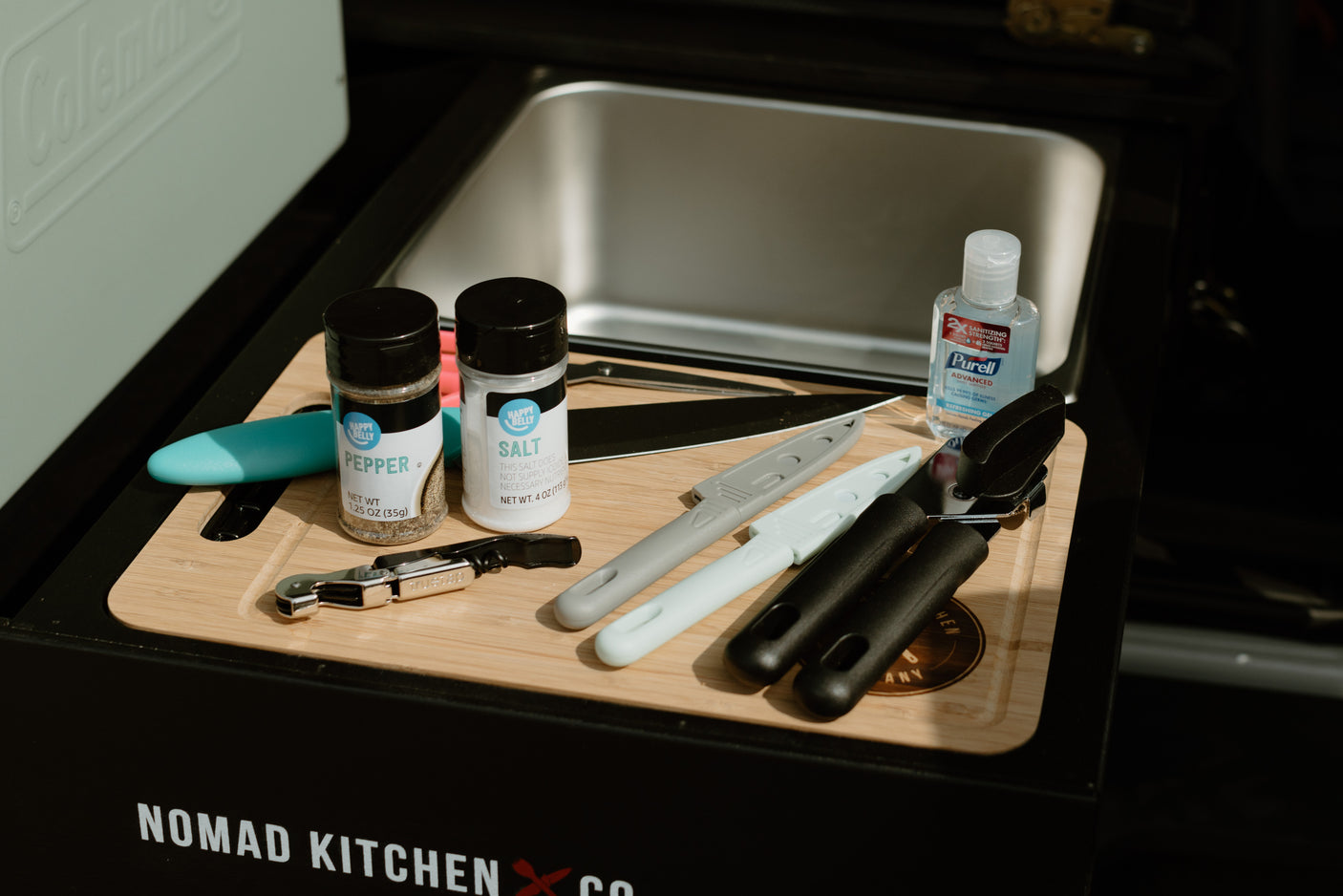 Perfect compact kitchen for your RV rental. Features a sink, cutting board, spices, utensils, and Purell for convenient outdoor cooking.