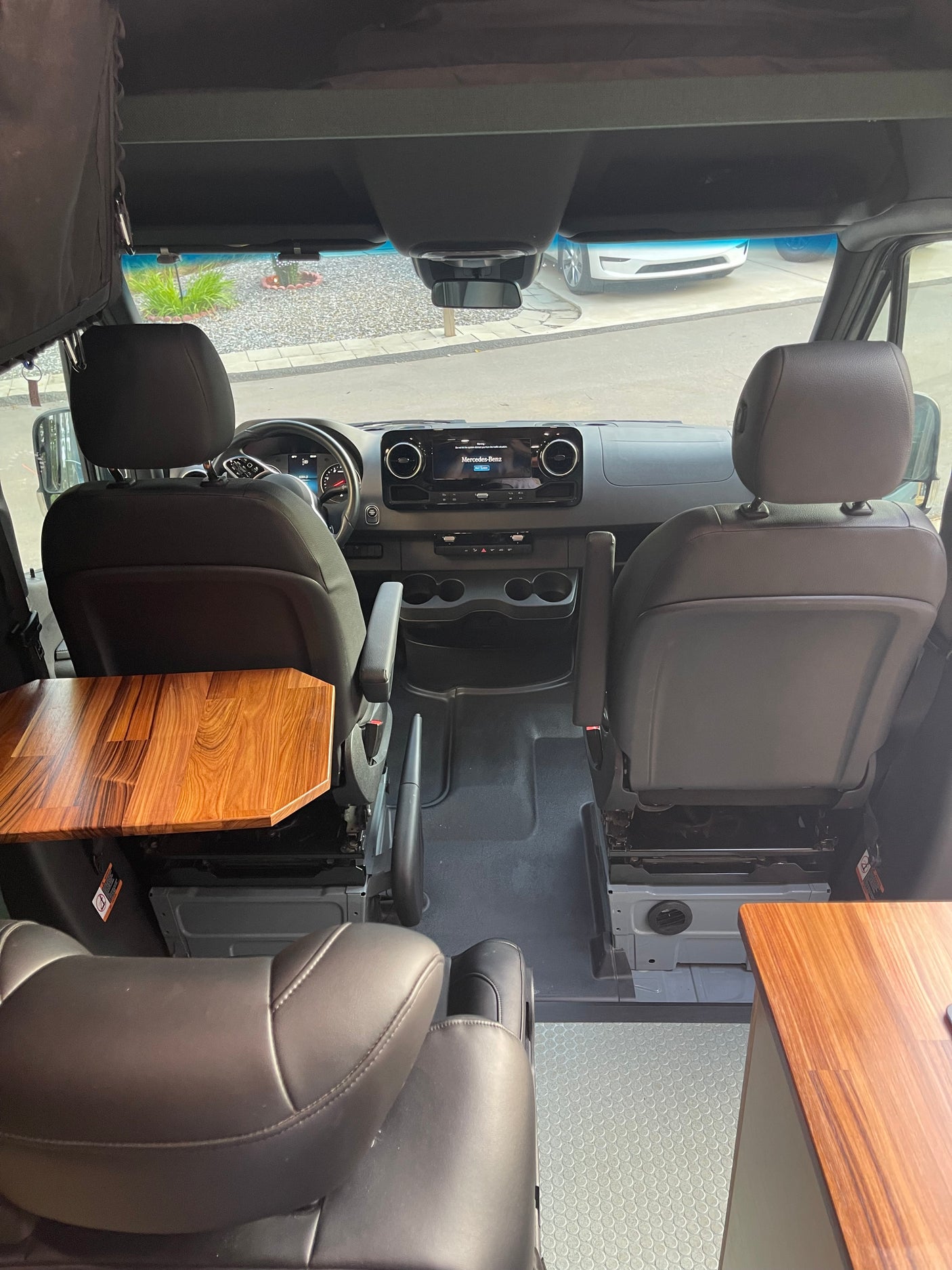 RV rental interior: Mercedes-Benz van with swivel seats, dashboard, and a built-in wooden table, ready for adventure.
