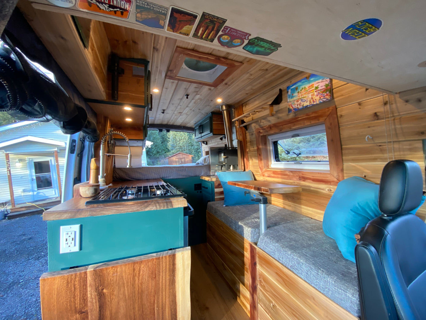 Beautiful wood-paneled RV rental interior with a full kitchen, built-in bed, and comfy dining bench for adventures.