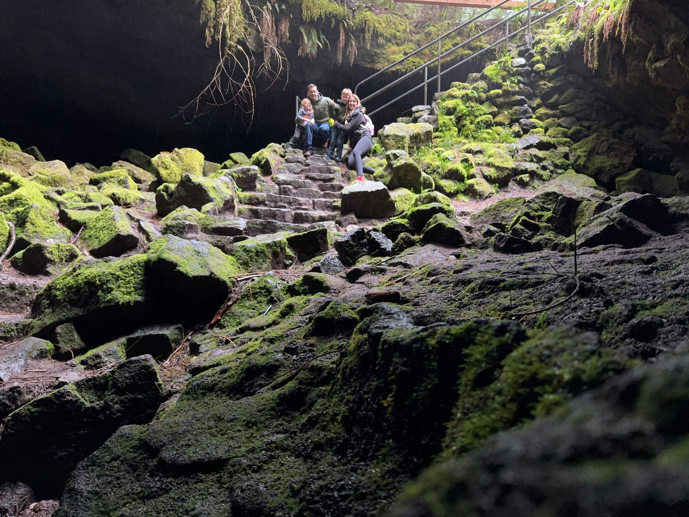 Family enjoying a mossy cave entrance, a perfect stop for your next RV rental adventure.