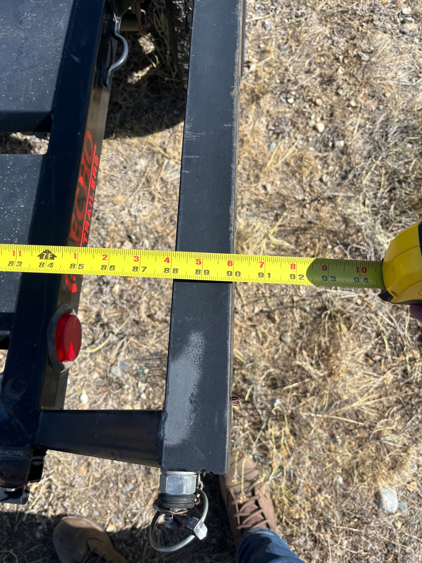 An RV rental trailer beam measured at 94 inches with a tape measure, showing ECHO TRAILERS branding.