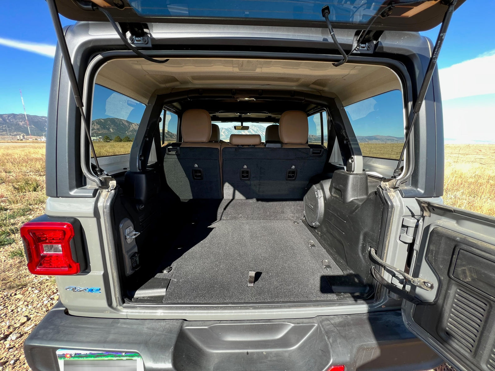 Spacious open rear cargo area of a Jeep Wrangler 4xe, ready for an RV rental adventure or outdoor trip with ample gear storage.