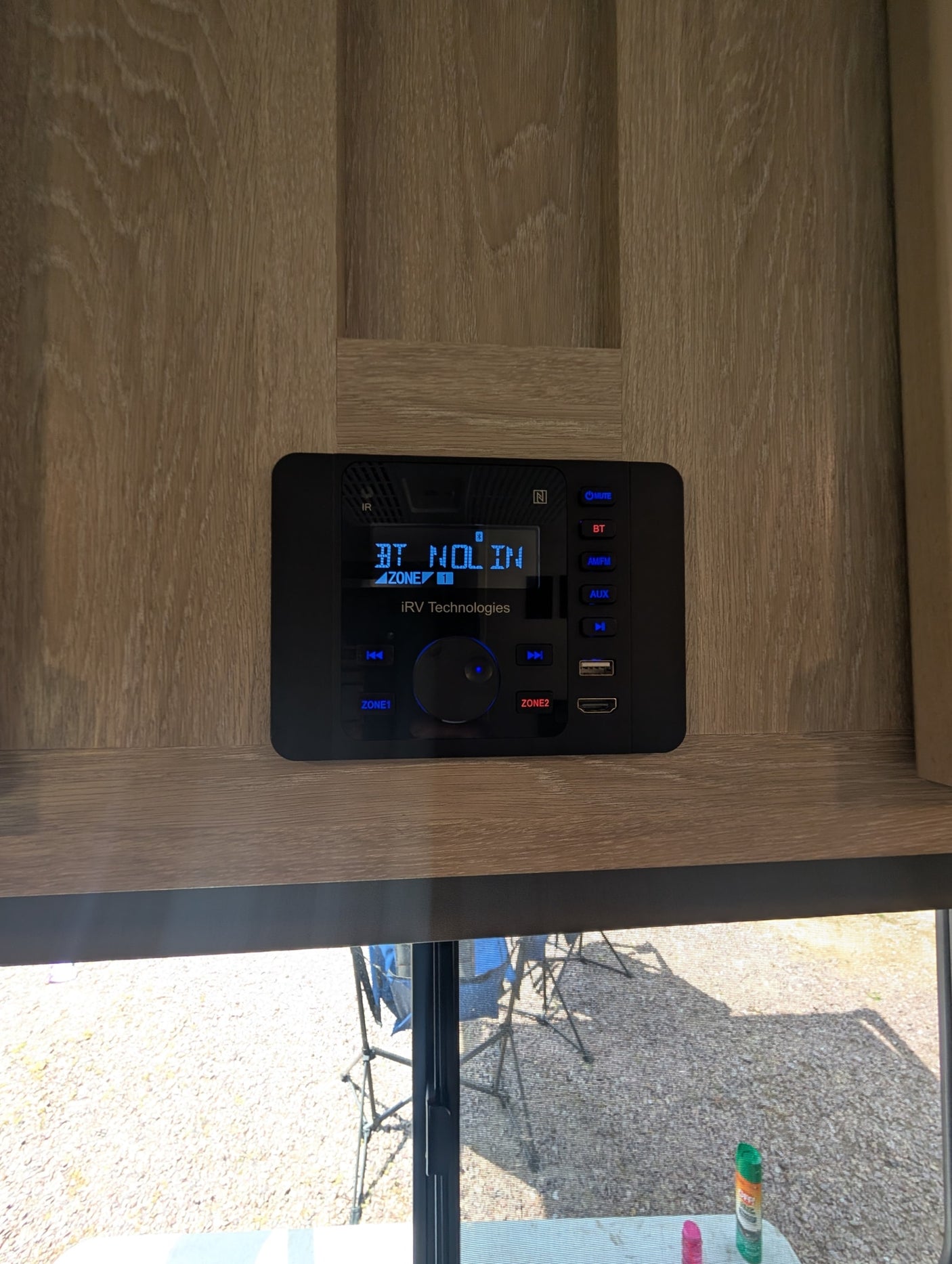 Close-up of an IRV Technologies multi-media audio system in an rv rental, displaying "BT NO LIN" with Bluetooth, USB, and HDMI.