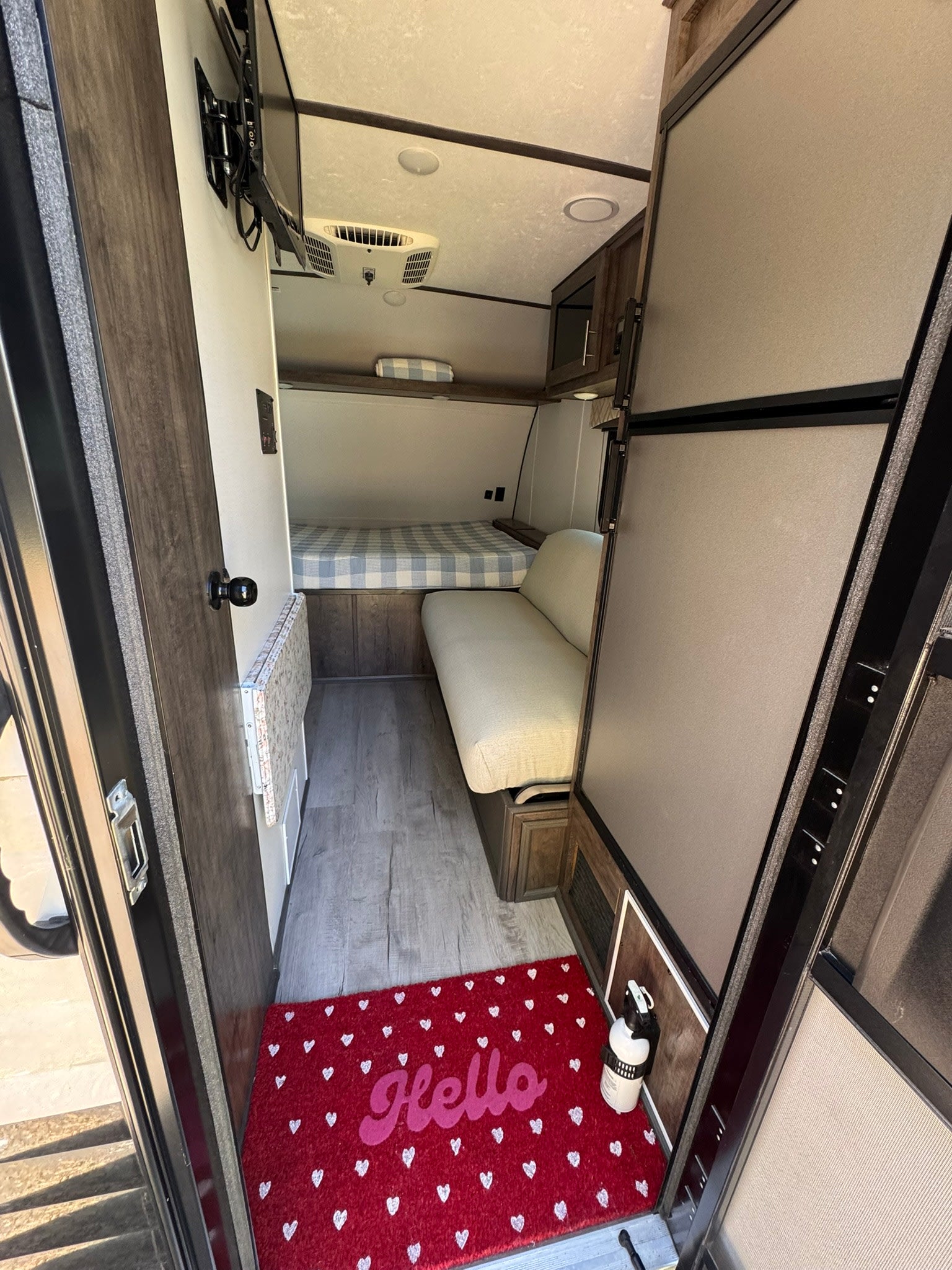 and a compact kitchen with a fold-down table near the open door.|RV rental bathroom: A tight space with a white toilet