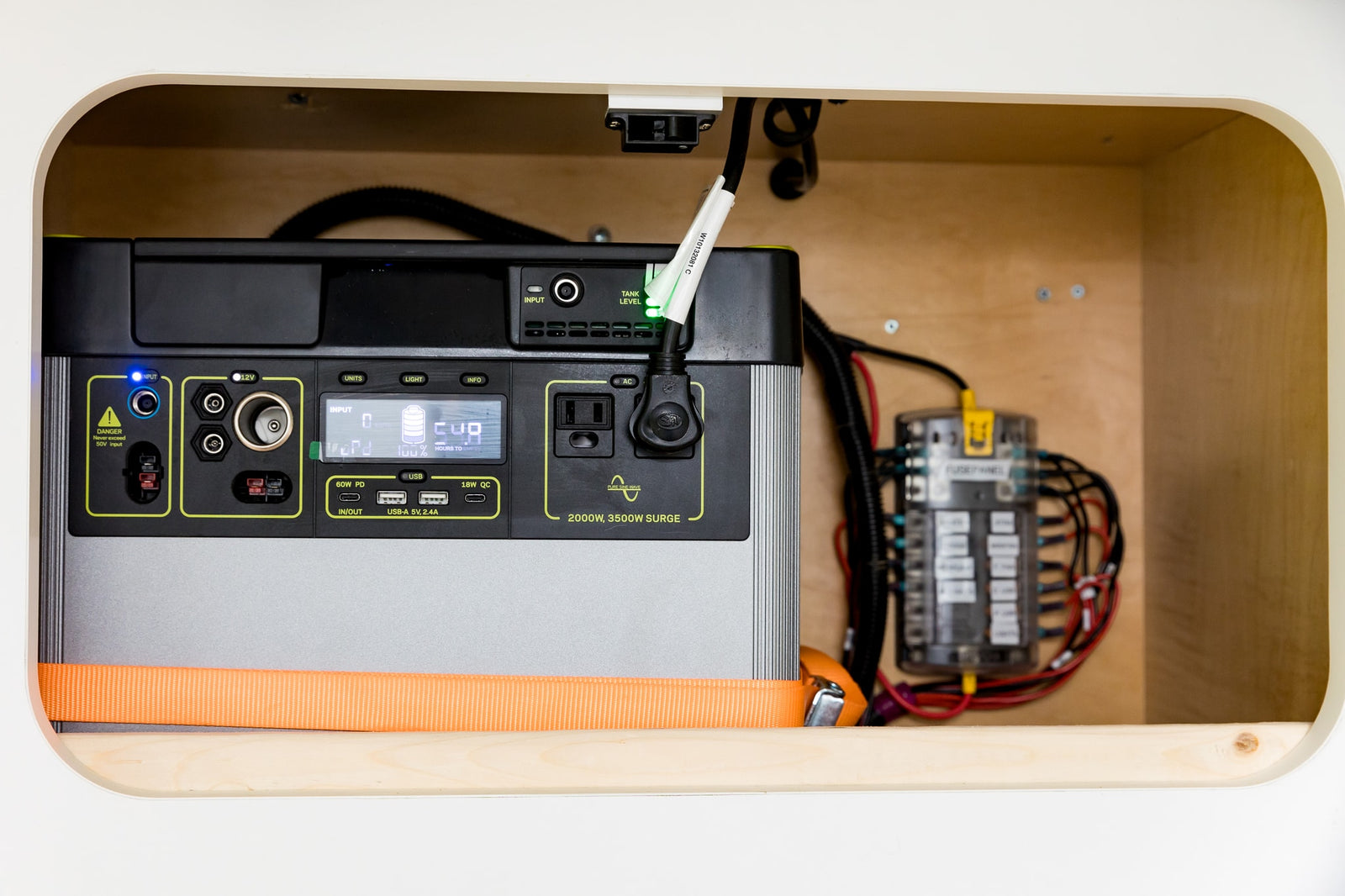 This RV rental's off-grid power setup: a secured portable power station and fuse panel inside a custom compartment.