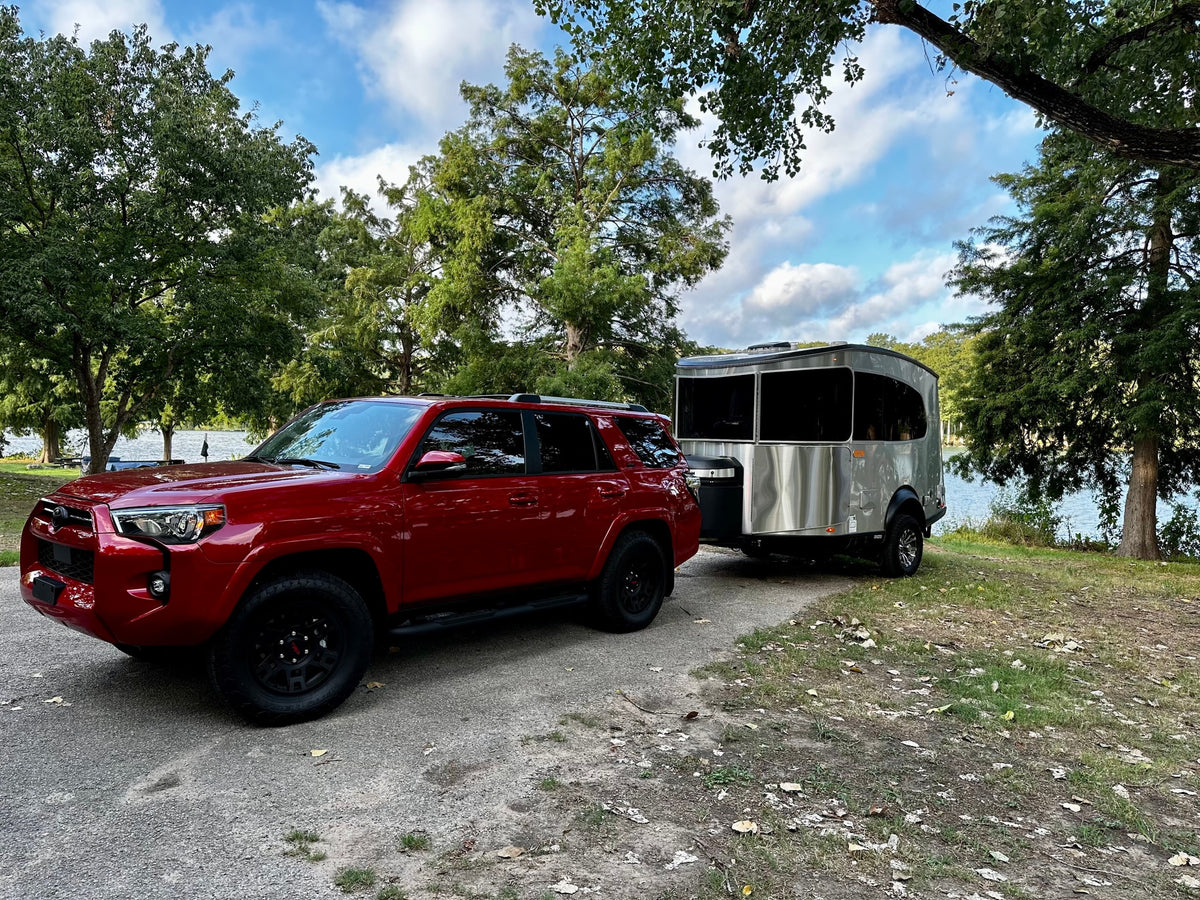 perfect for your next RV rental adventure by the lake.|Close-up of an RV rental: silver travel trailer with black fender — photo 2
