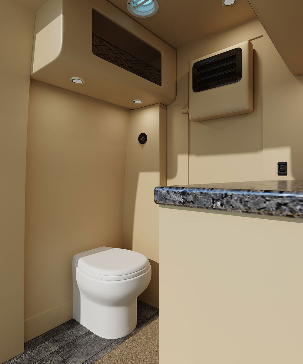 RV rental: Cozy interior with compact toilet, stone-look counter, overhead storage, & wall vent.