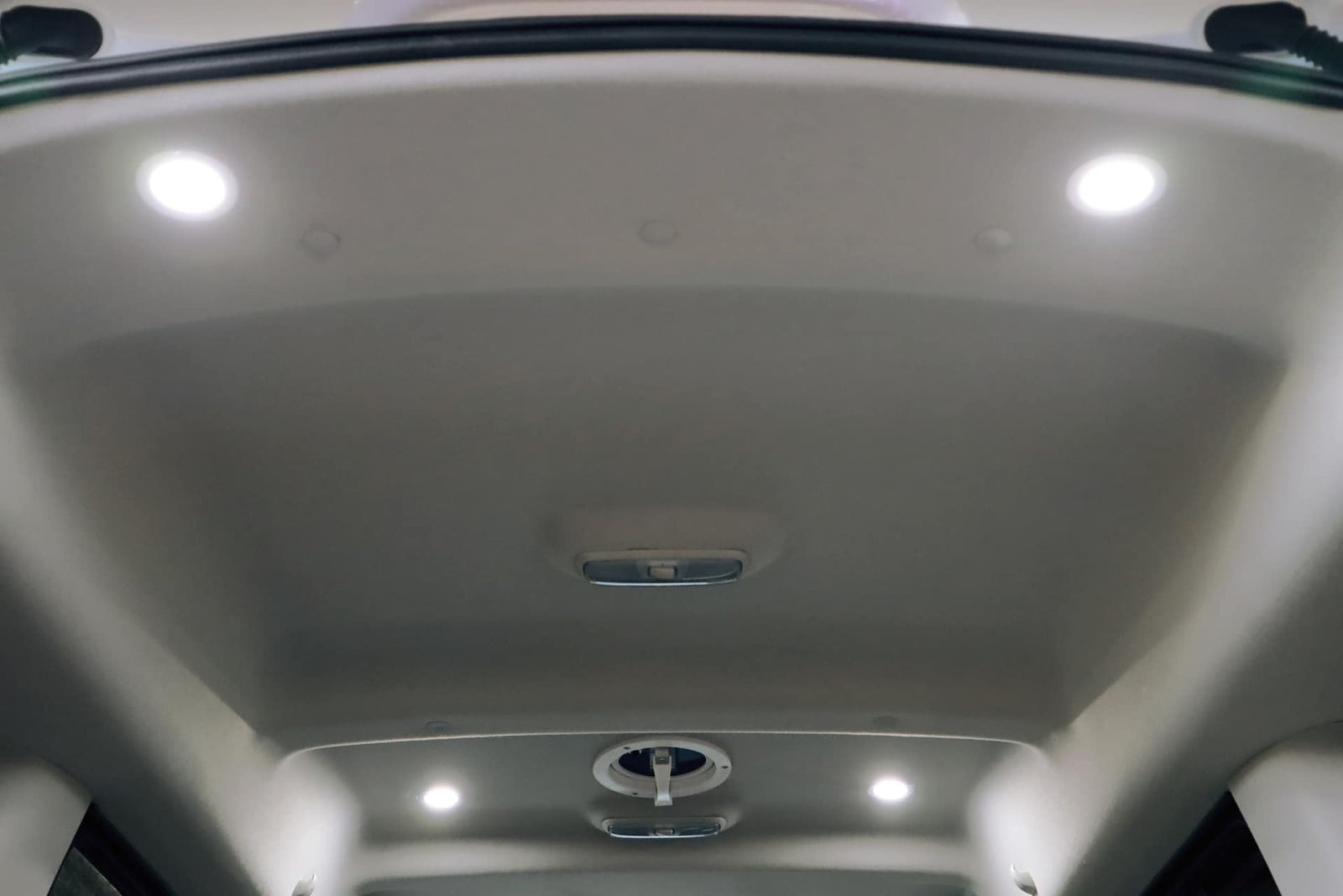 Bright, modern RV rental interior showing ceiling with four LED lights and various ventilation features.