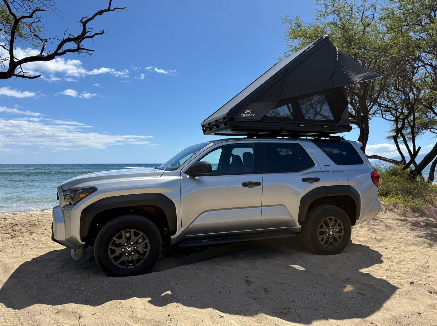 parked by the ocean in Hawaii.|Discover adventure! This silver SUV with a Topoak rooftop tent is on a sandy beach — photo 5