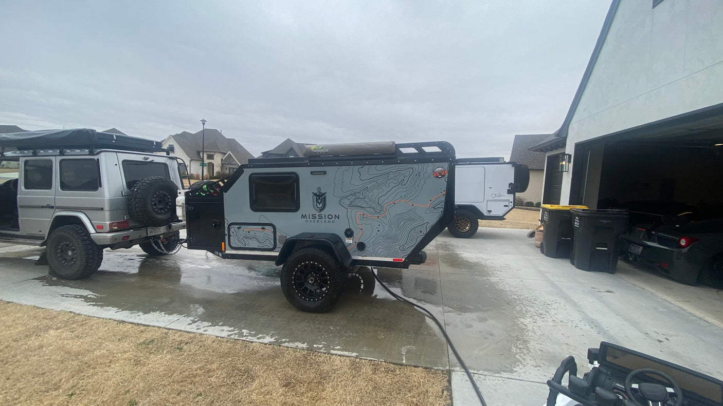 A G-Wagon tows a sleek Mission Overland RV trailer, ready for adventure. Explore RV rental options for similar trips!