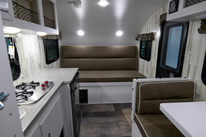 parked on a snowy lot with other campers.|A Rove Lite compact travel trailer