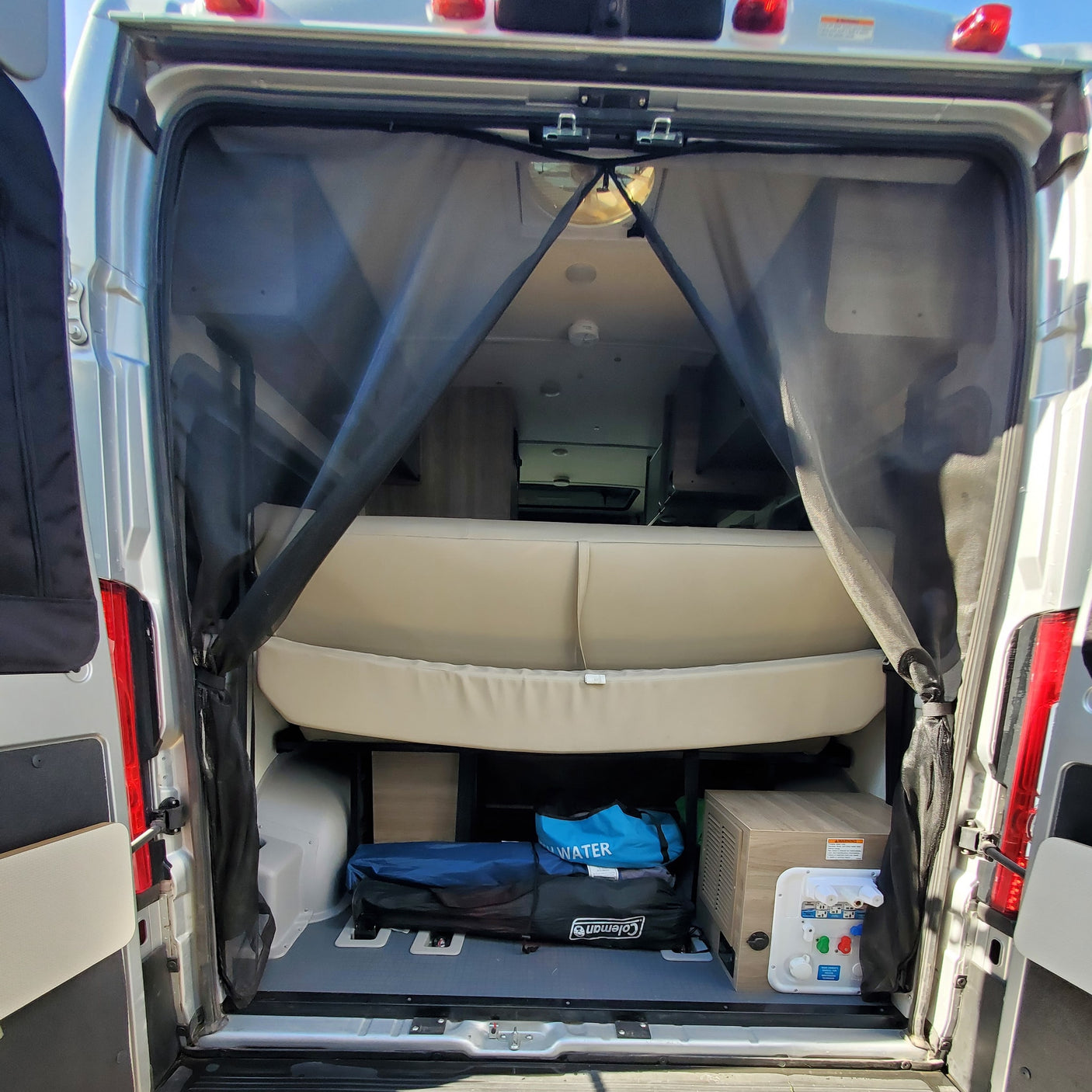 and comfortable patterned rear seating.|Explore this modern RV rental interior featuring a compact kitchen