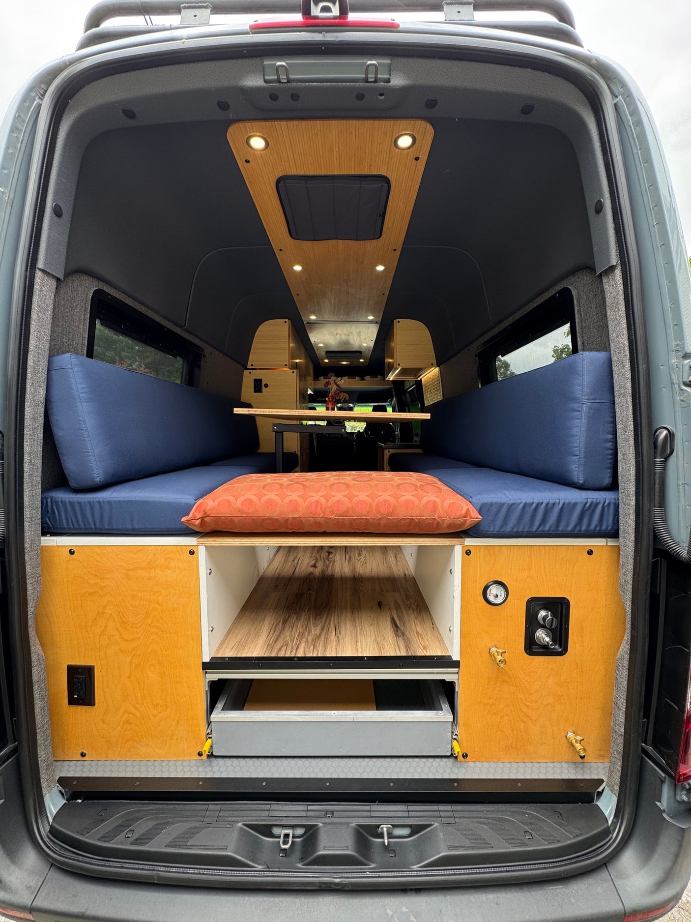 and a touch of nature create a cozy travel space.|Modern RV rental kitchenette features a black faucet