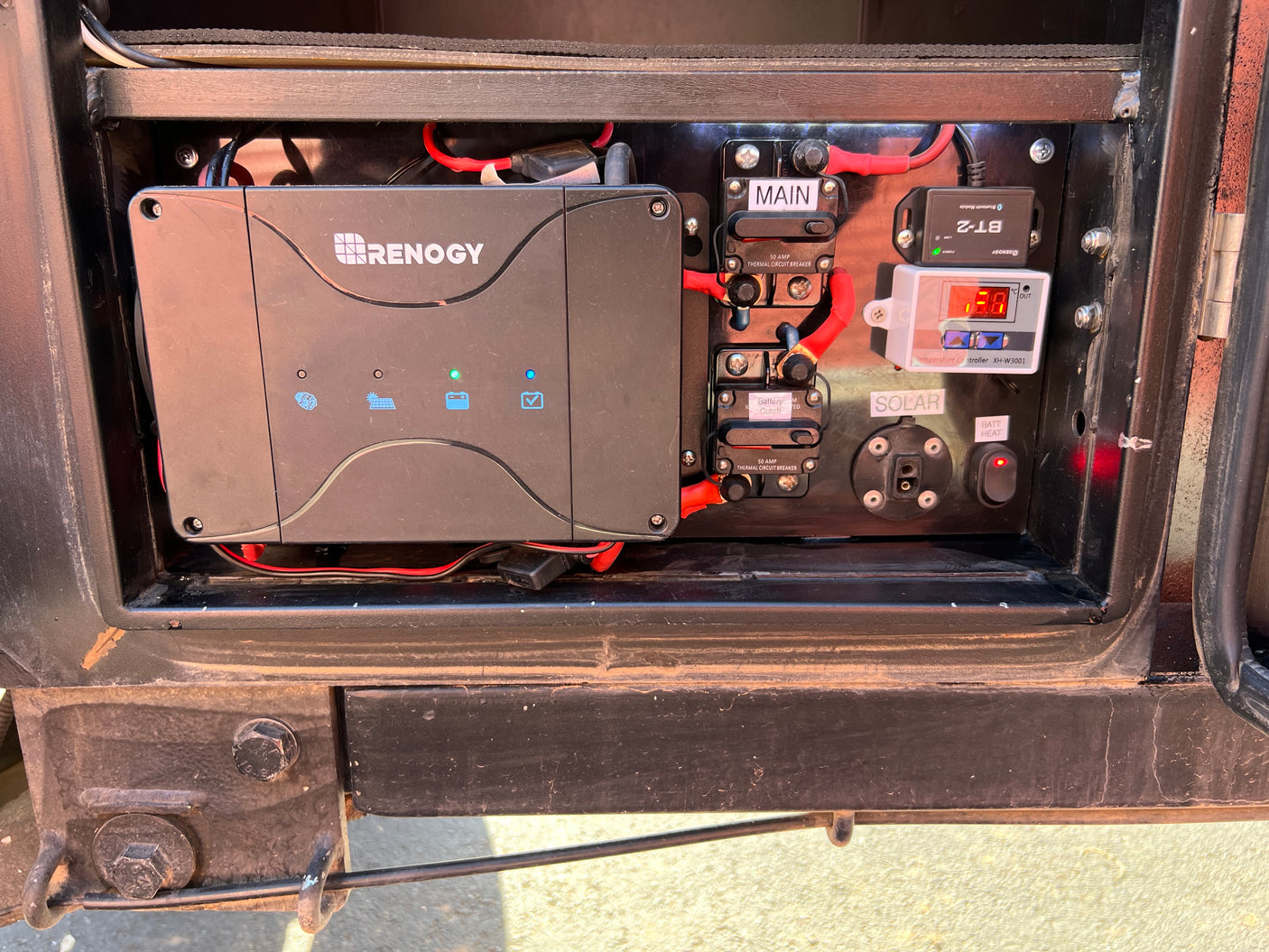 Detailed view of an RV rental's Renogy solar charge controller, circuit breakers, temperature controller, and power connections.