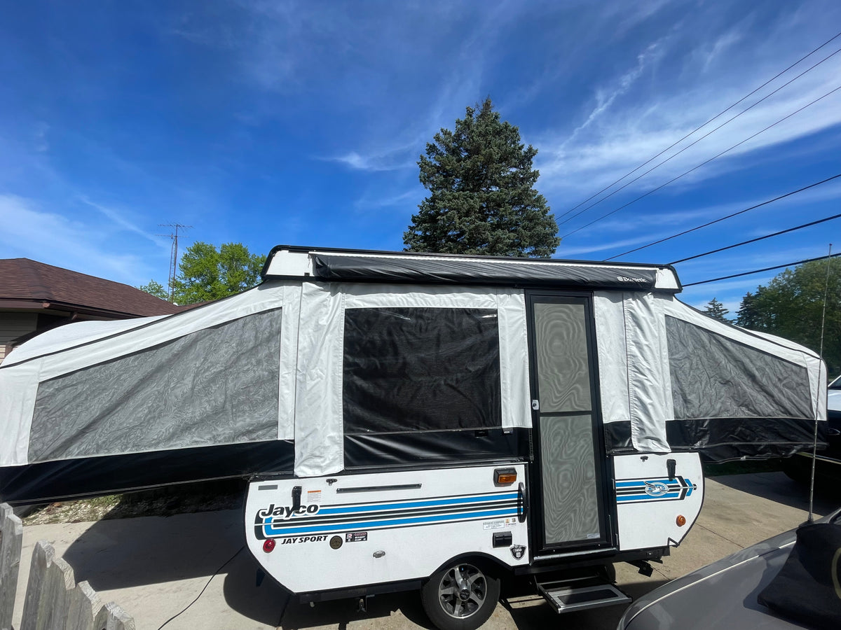 This Jayco pop-up RV rental, a Jay Sport camper, is fully set up outdoors, ready for your next adventure.