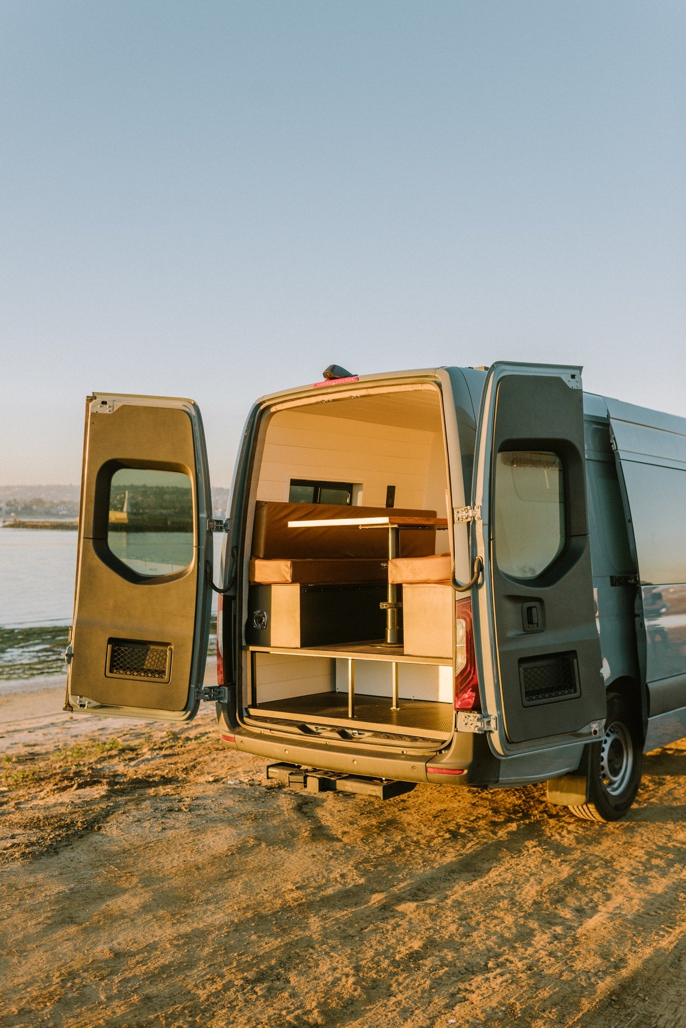 Open the doors to adventure! This custom camper van is ideal for your rv rental escape, parked by the water with its cozy interior. — photo 15