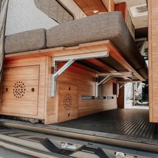 a camper van conversion reveals a kitchen on the right