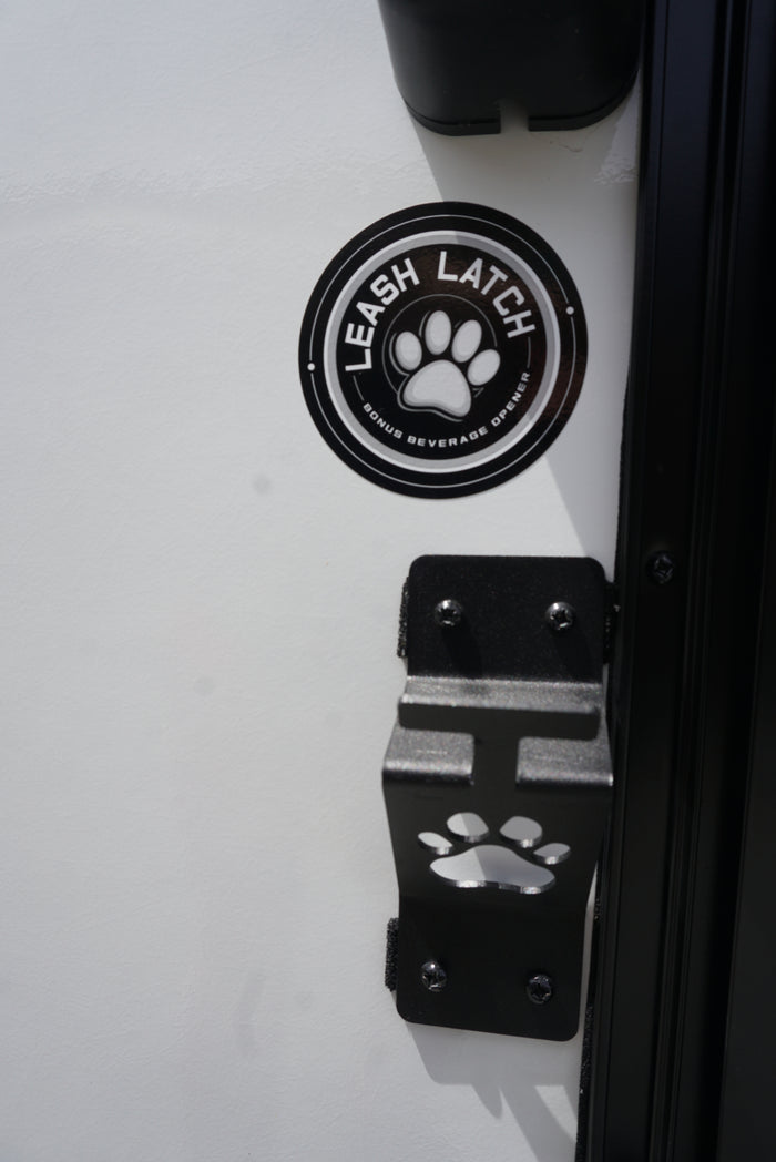 RV rental: Close-up of a "Leash Latch" paw print bracket & sticker, also a bonus beverage opener. Perfect for pet adventures.