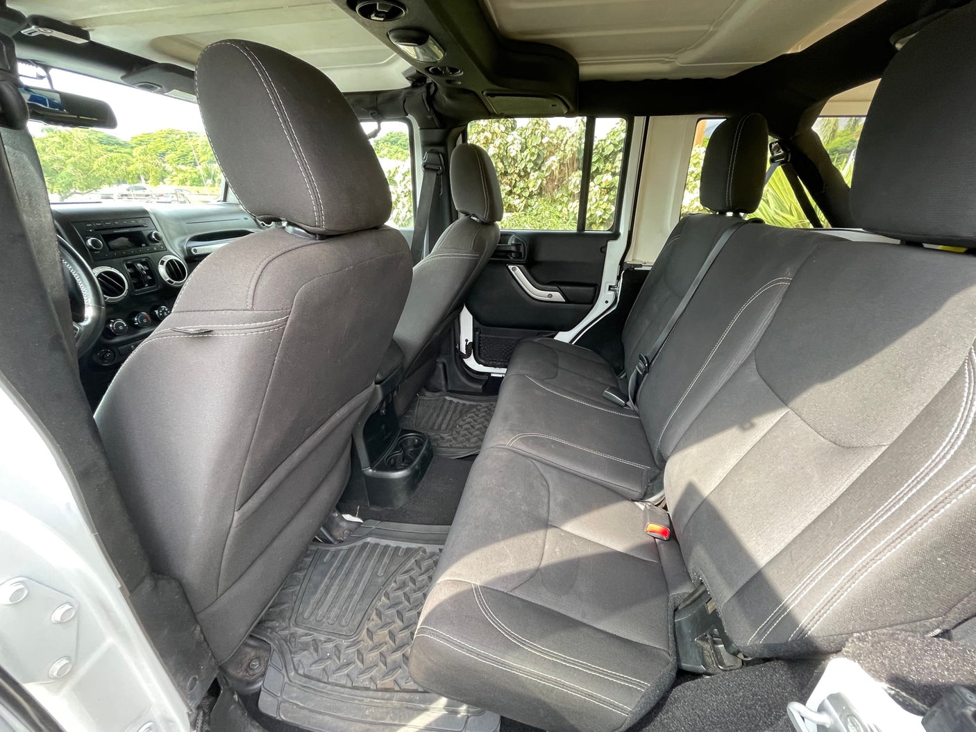 Inside this clean RV rental: black fabric rear seats with white stitching and rugged floor mats.