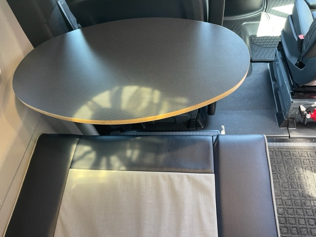 RV rental: view of a spacious oval table & two-tone bench seating. Compact and functional interior design.