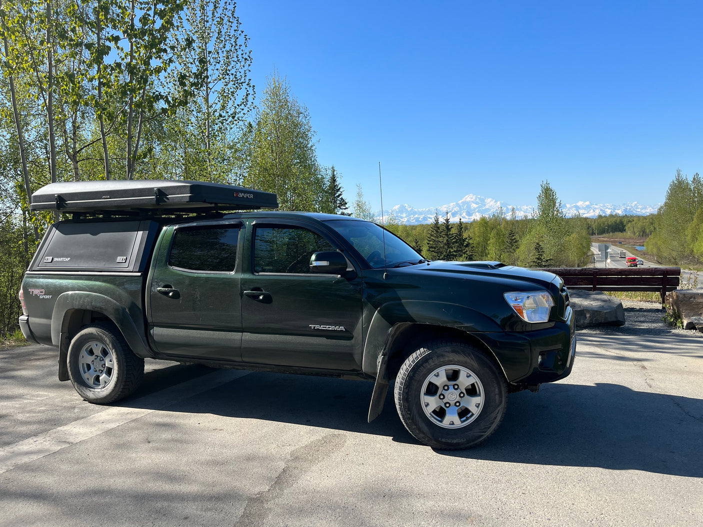 Dark green Tacoma overland rig with rooftop tent & camper. Perfect for adventure, exploring beyond typical RV rental options.