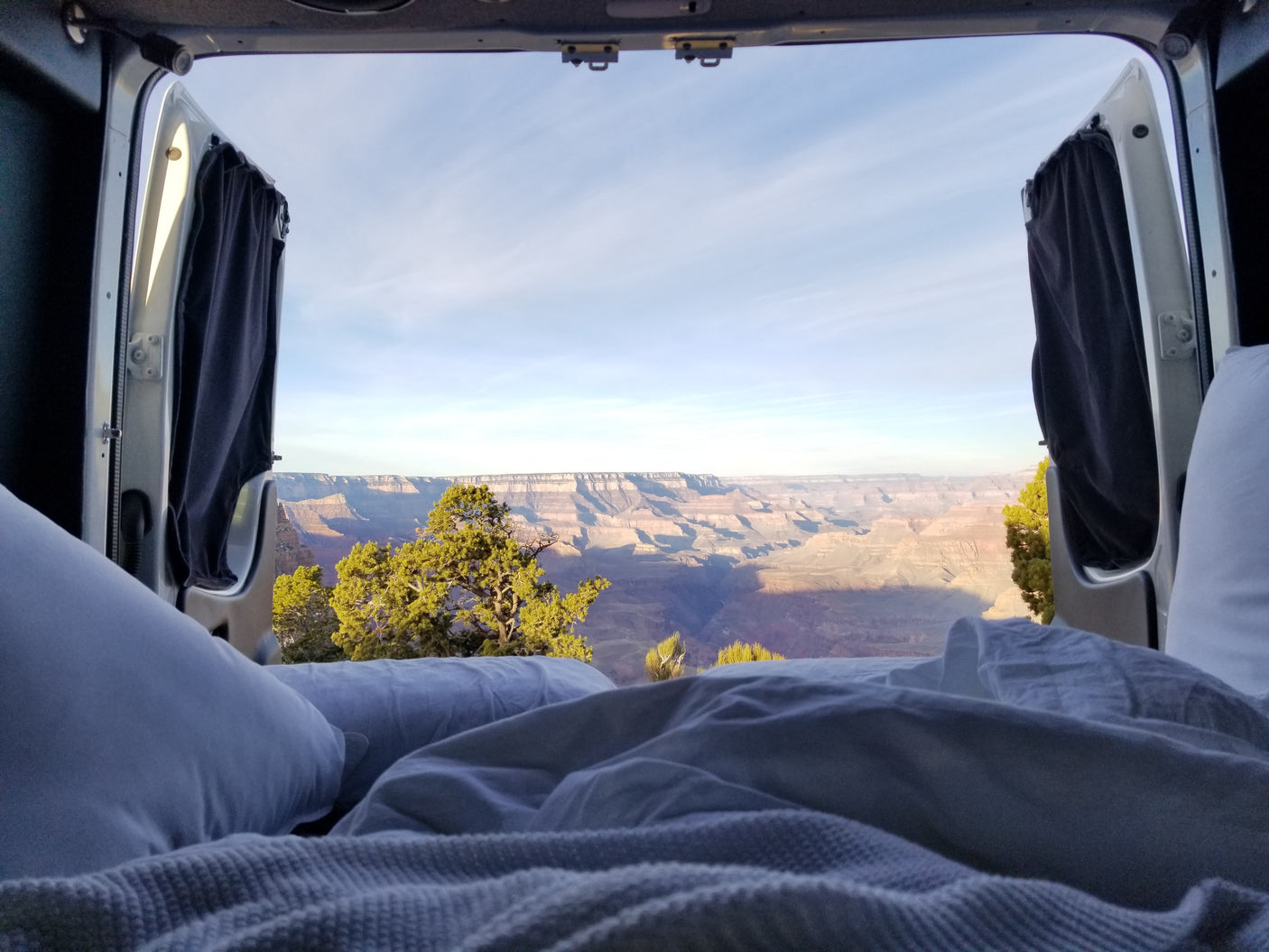 Waking up to the Grand Canyon! View from a cozy RV rental bed with open doors. Epic nature experience.