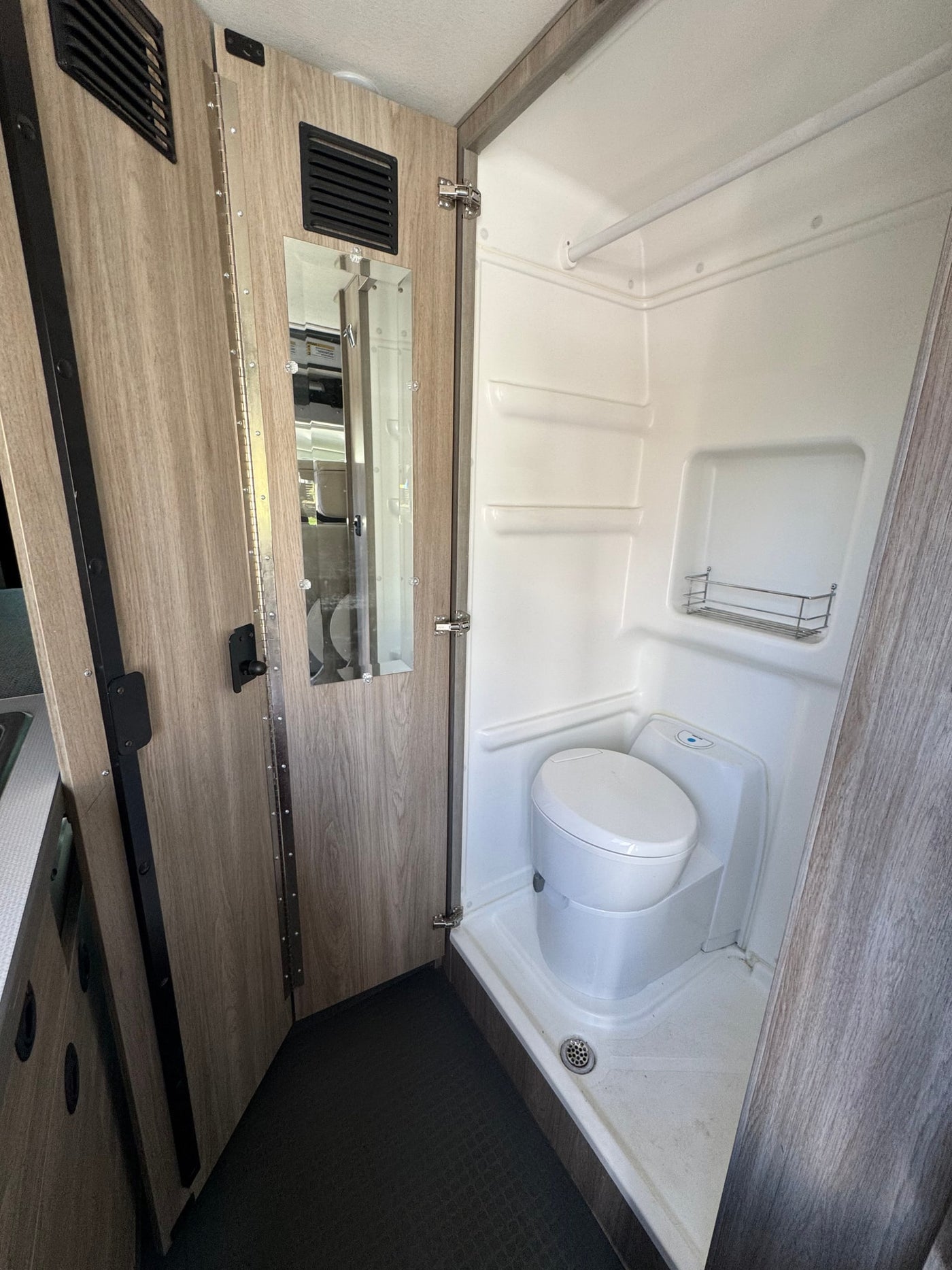 Compact RV rental wet bath with toilet and shower inside a camper van. — photo 4