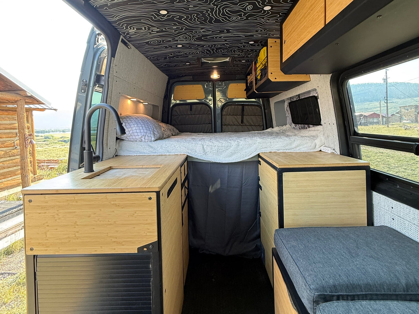 and wood accents.|Modern rv rental van conversion with bamboo kitchen — photo 5