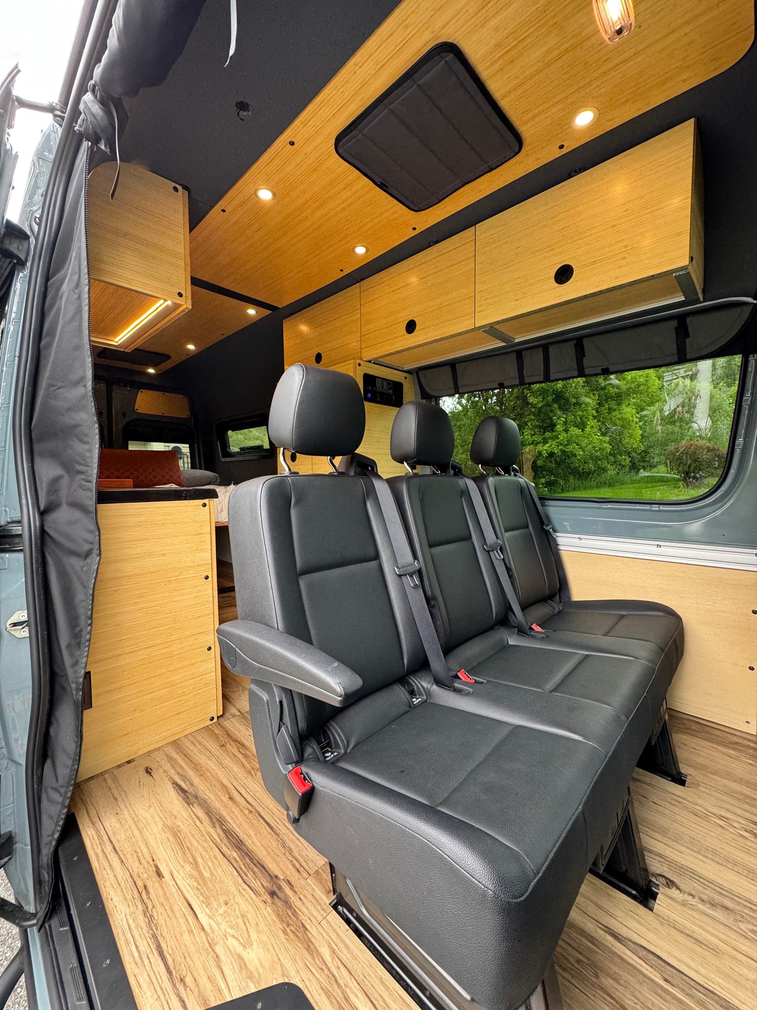 and cozy bed.|Spacious RV rental interior featuring a wooden dining table