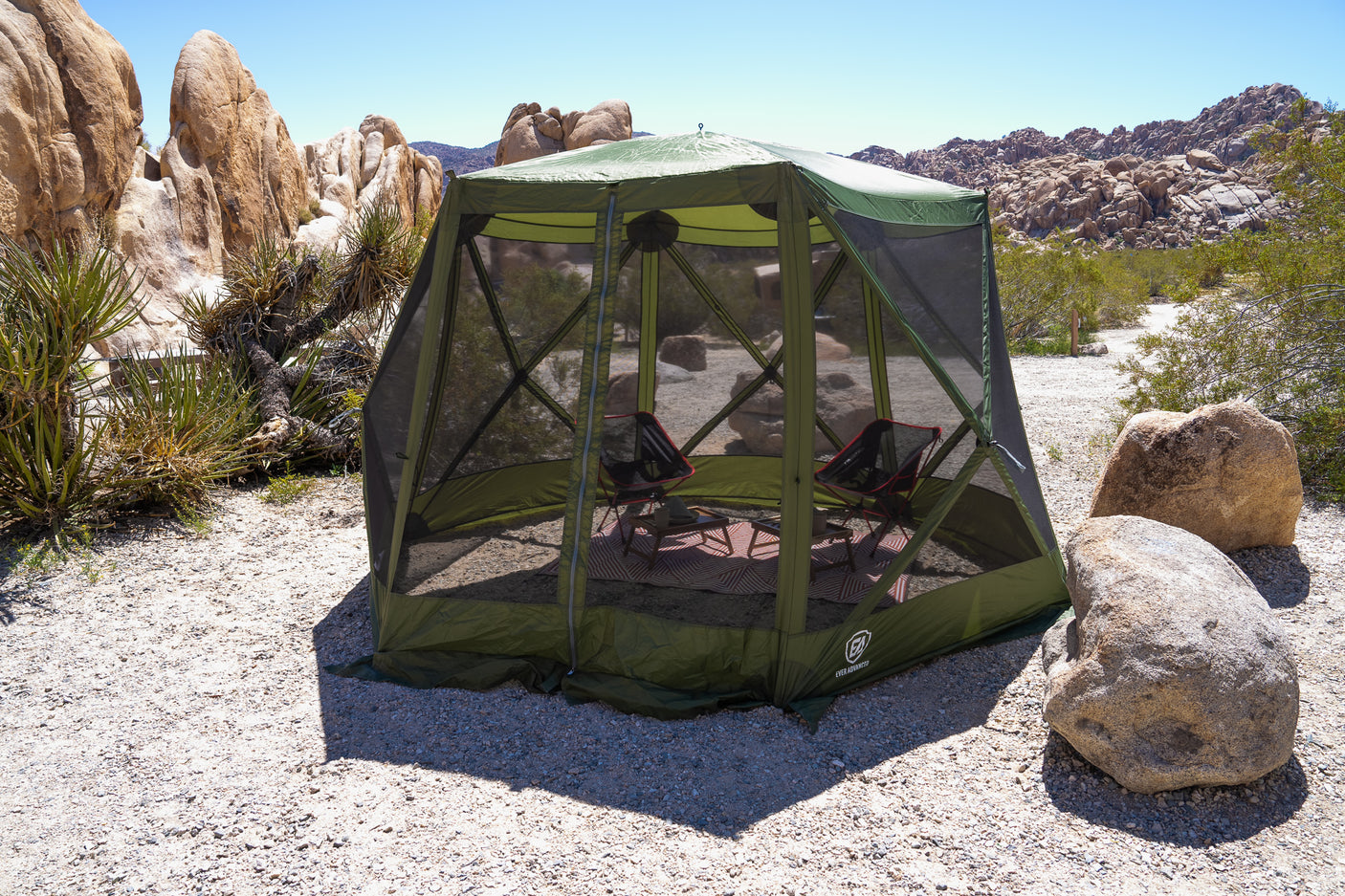 Green pop-up screen house in a rocky desert, perfect outdoor shelter for your RV rental adventure. Campsite comfort.