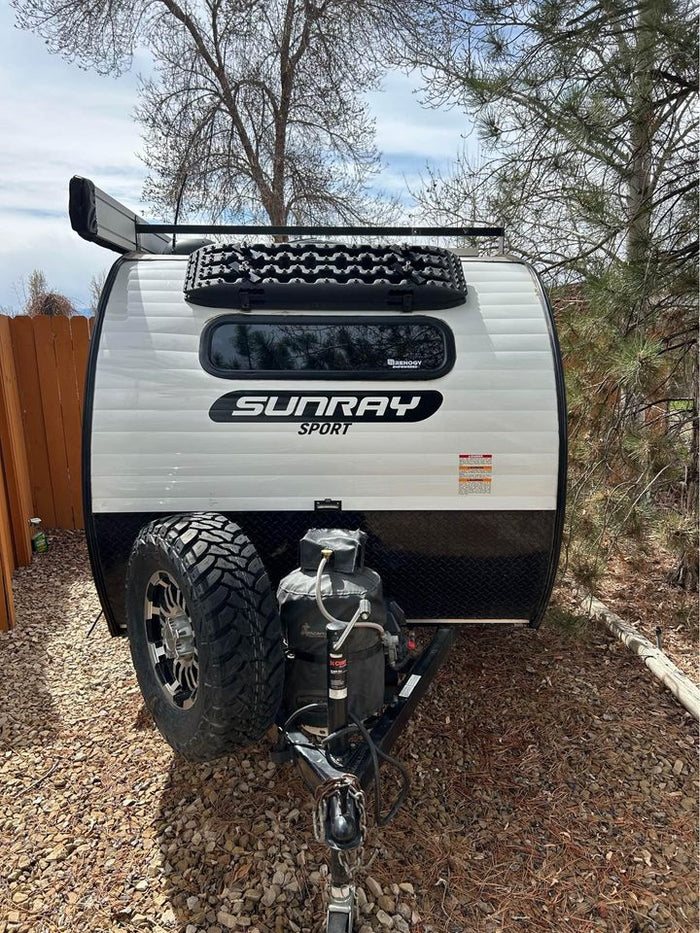 a white camper trailer with roof racks