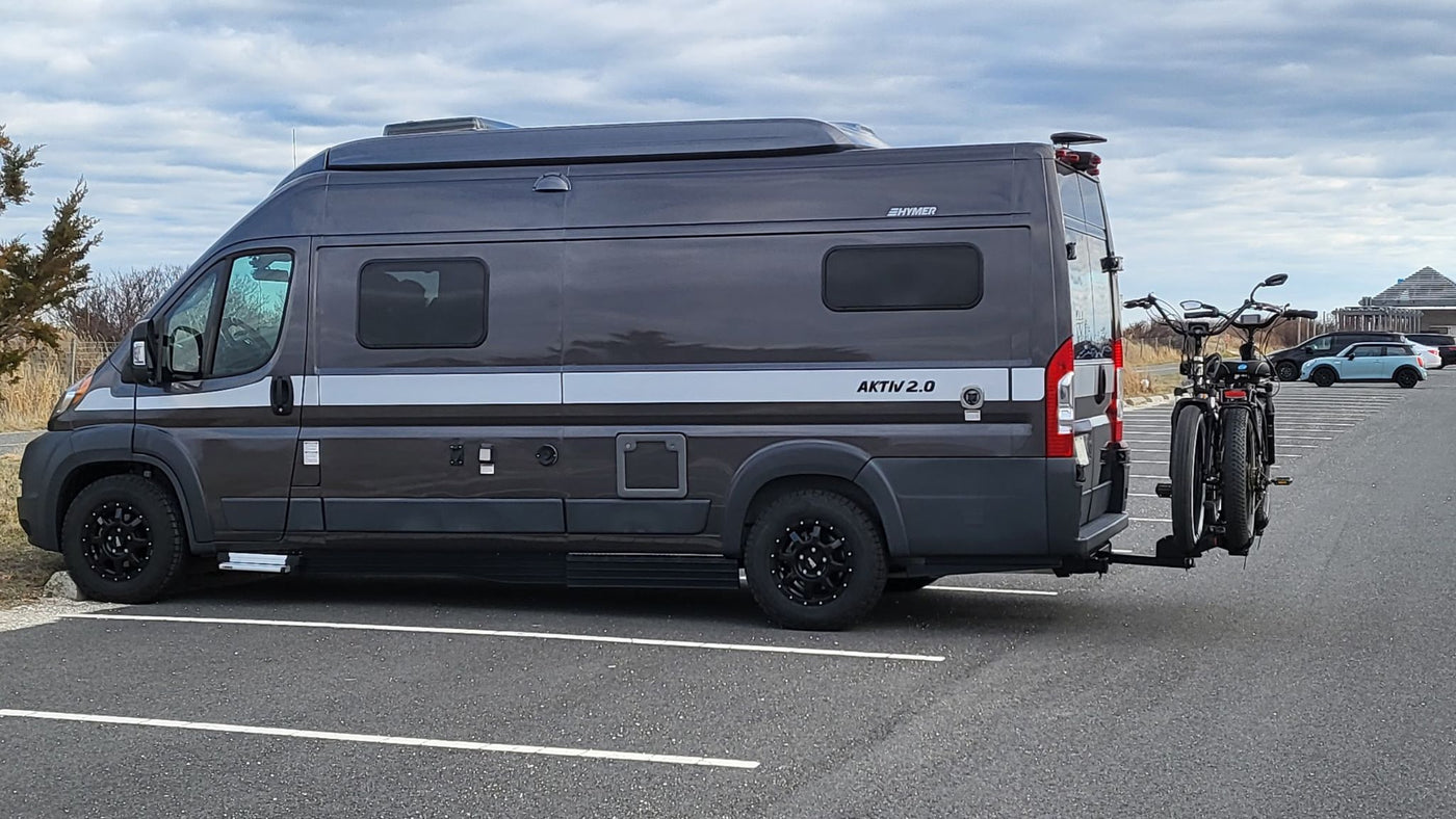 and day/night interior layouts.|This RV rental image displays top-down day and night layouts. The day layout features seating and kitchen; the night layout converts to a bed.|A stylish dark grey Hymer Aktiv 2.0 camper van — photo 4