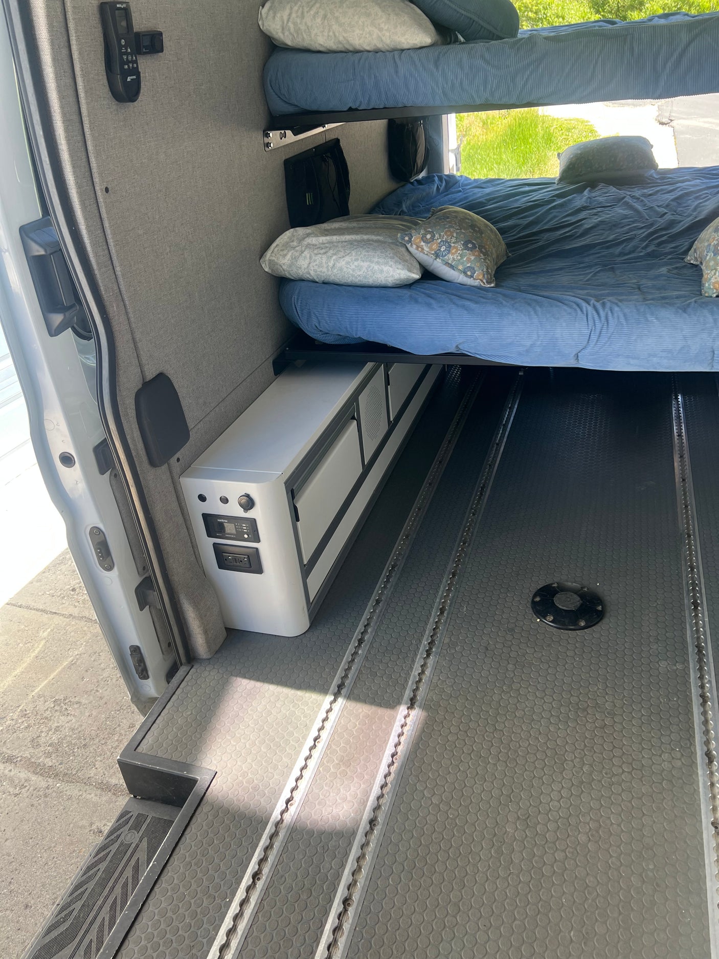 An RV rental's organized interior with bunk beds, Dometic fridge, and durable L-track floor.