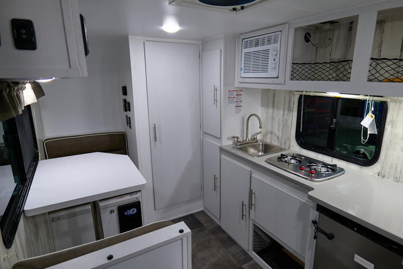 parked in a snowy sales lot.|White Rove Lite travel trailer