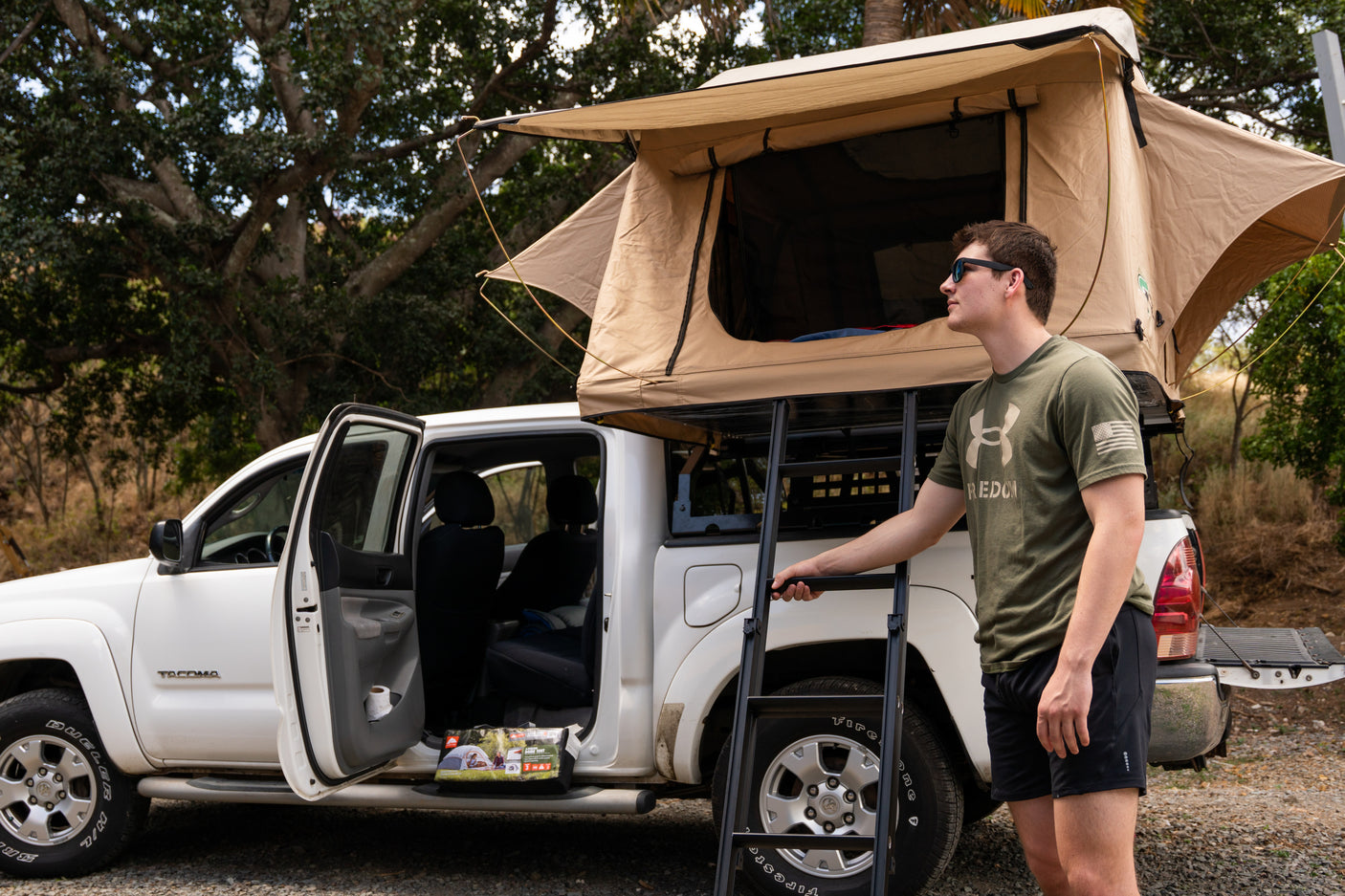 Man prepares for adventure with a truck rooftop tent, a great RV rental alternative for camping.